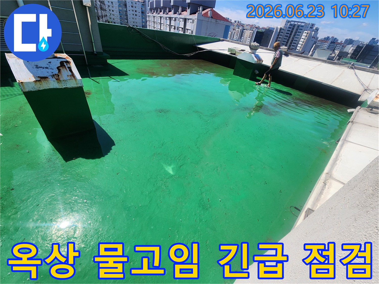 이 이미지는-송파구 옥상에서-누수 발생 가능성이 있는-물고임 현상을-전문가가 긴급 점검하는 모습입니다.