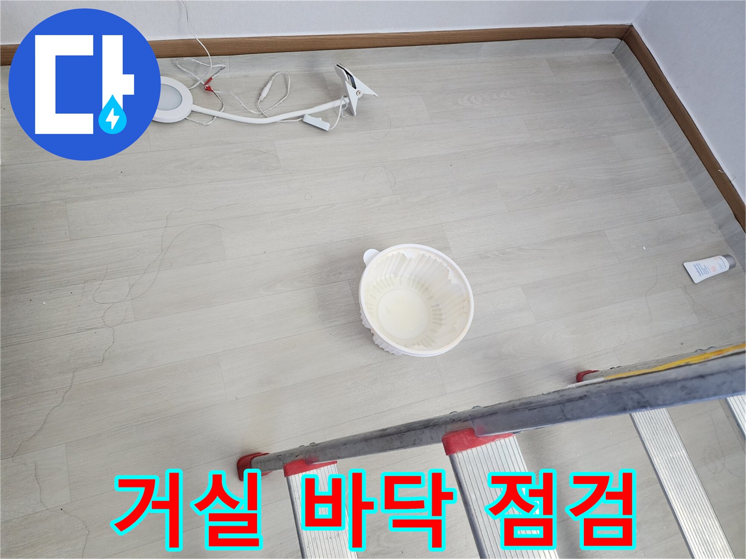 작업용 사다리와 바닥의 균열된 마루를 촬영한 누수 점검 현장
