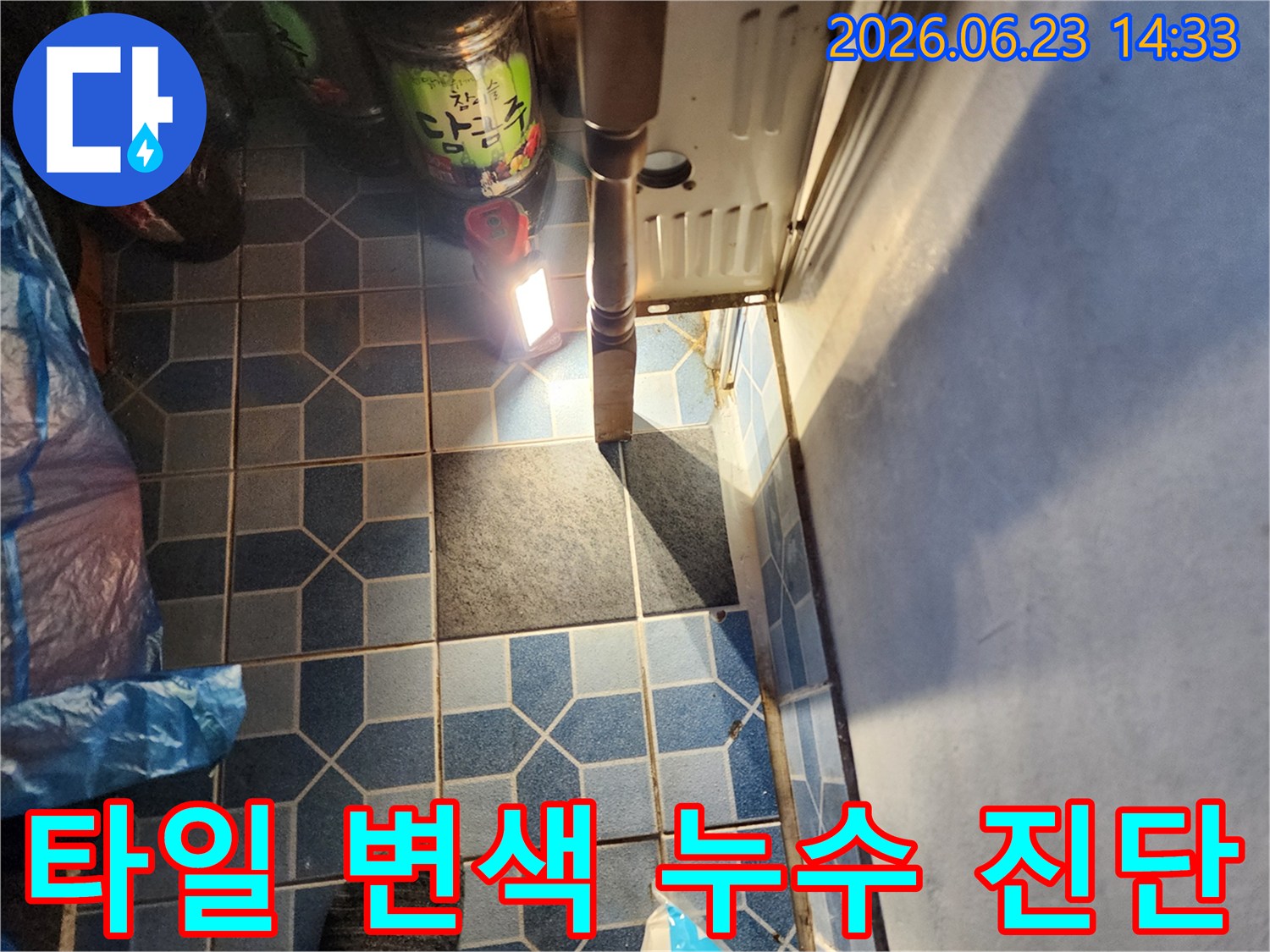 누수 전문가가-강북구 월계동 신성그랜드빌 욕실 바닥 타일의-변색된 부분을-누수 징후로 판단하고-정밀 진단을 준비하는 모습