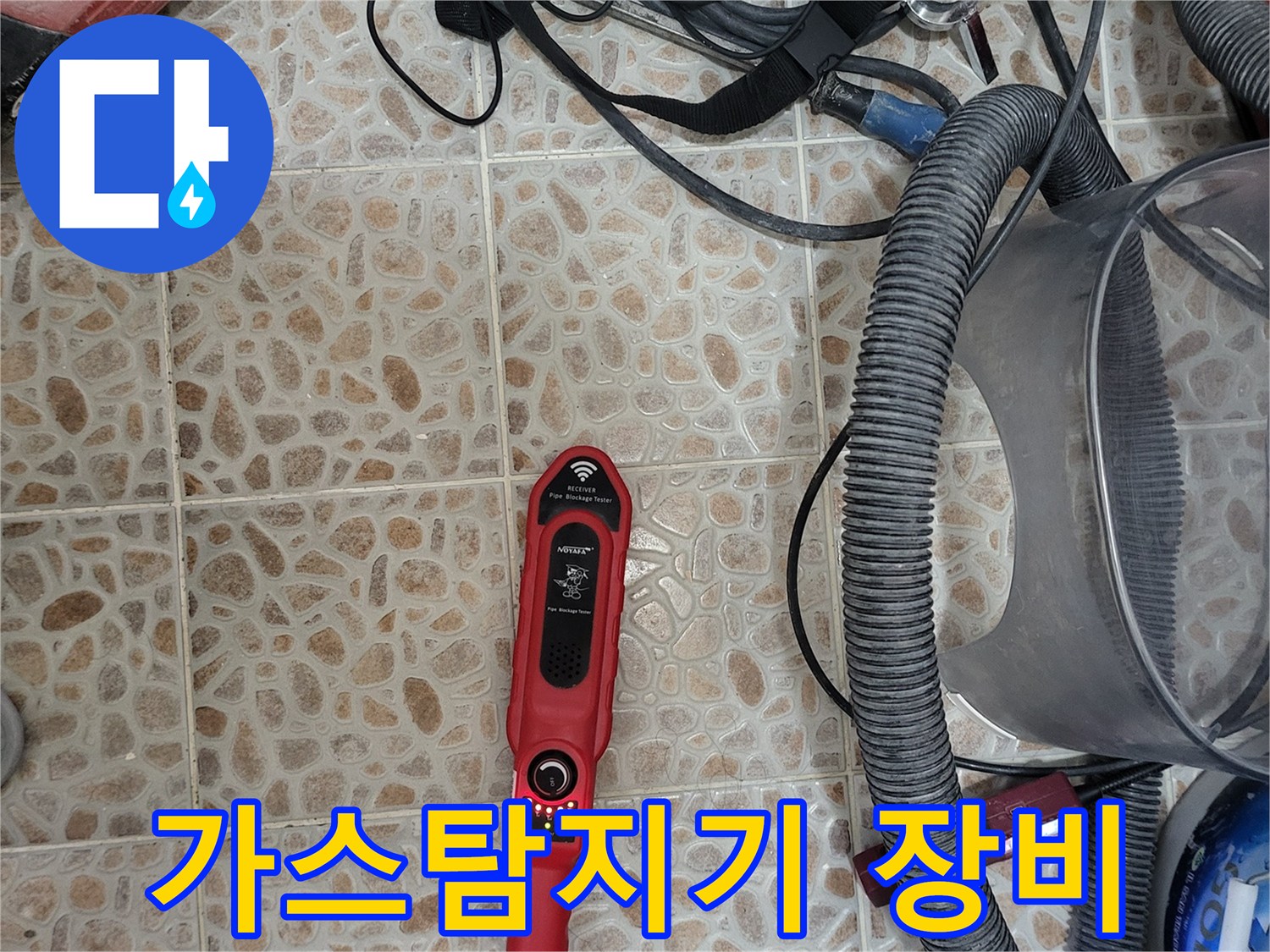 누수 지점을 찾기 위해 바닥에 놓인 빨간색 가스 탐지기