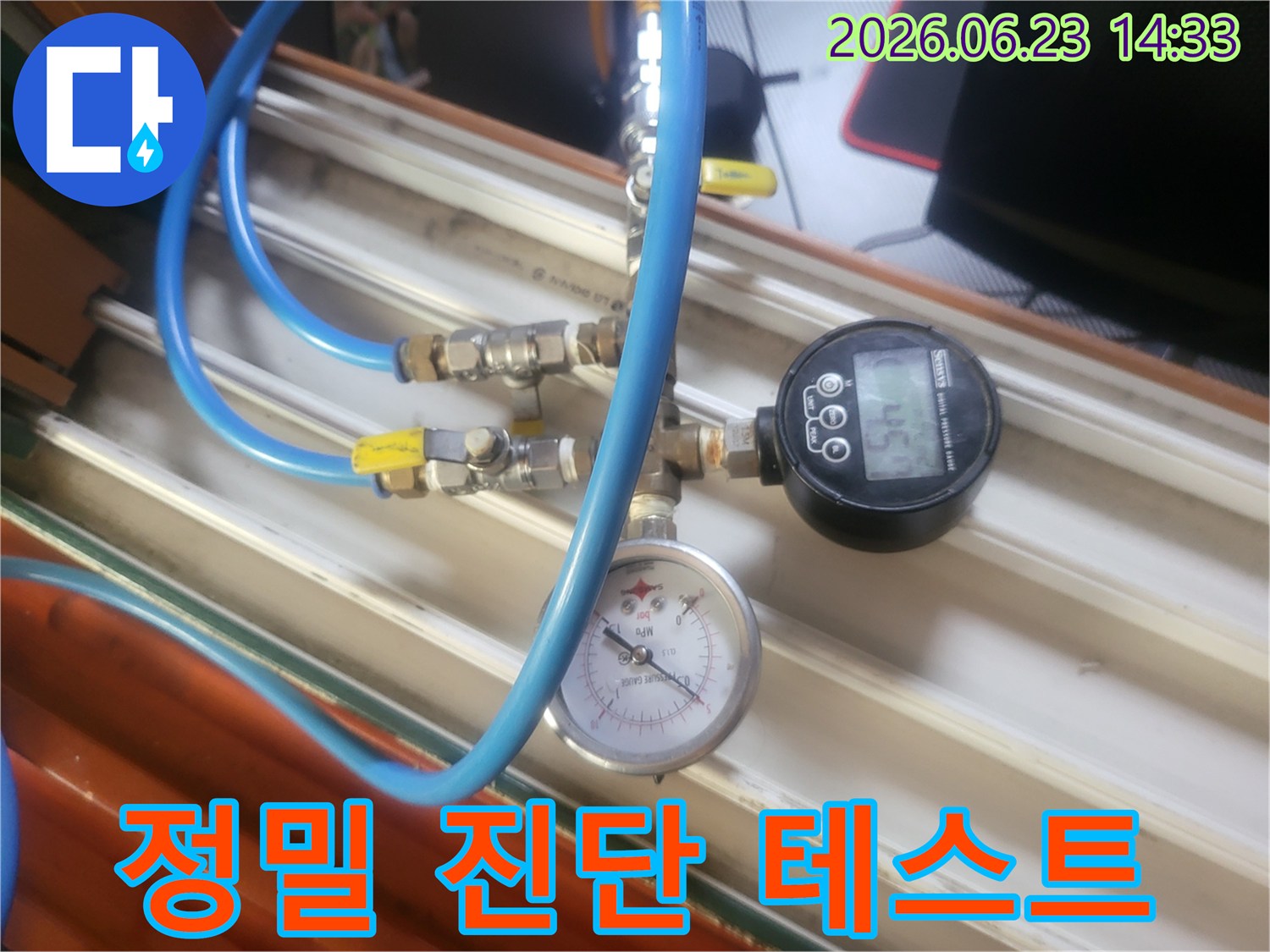누수 탐지를 위해-배관에 연결된-압력계와-디지털 게이지-그리고 파란색 호스들이-보이는 모습입니다.