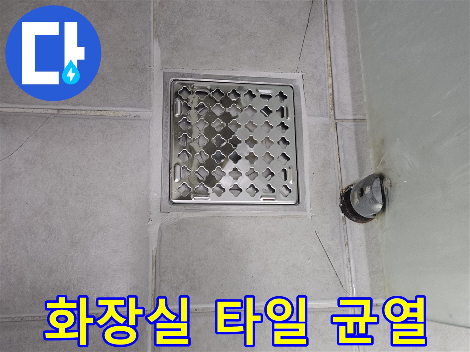 금 간 타일 사이와 노출된 배수관 연결 부위