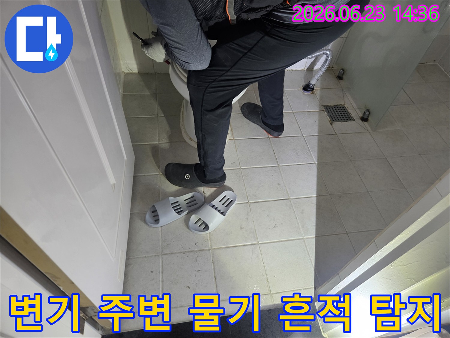 누수 엔지니어가-사무실 화장실 변기 주변의-미세한 물기 흔적을-집중적으로 탐지하고 있습니다