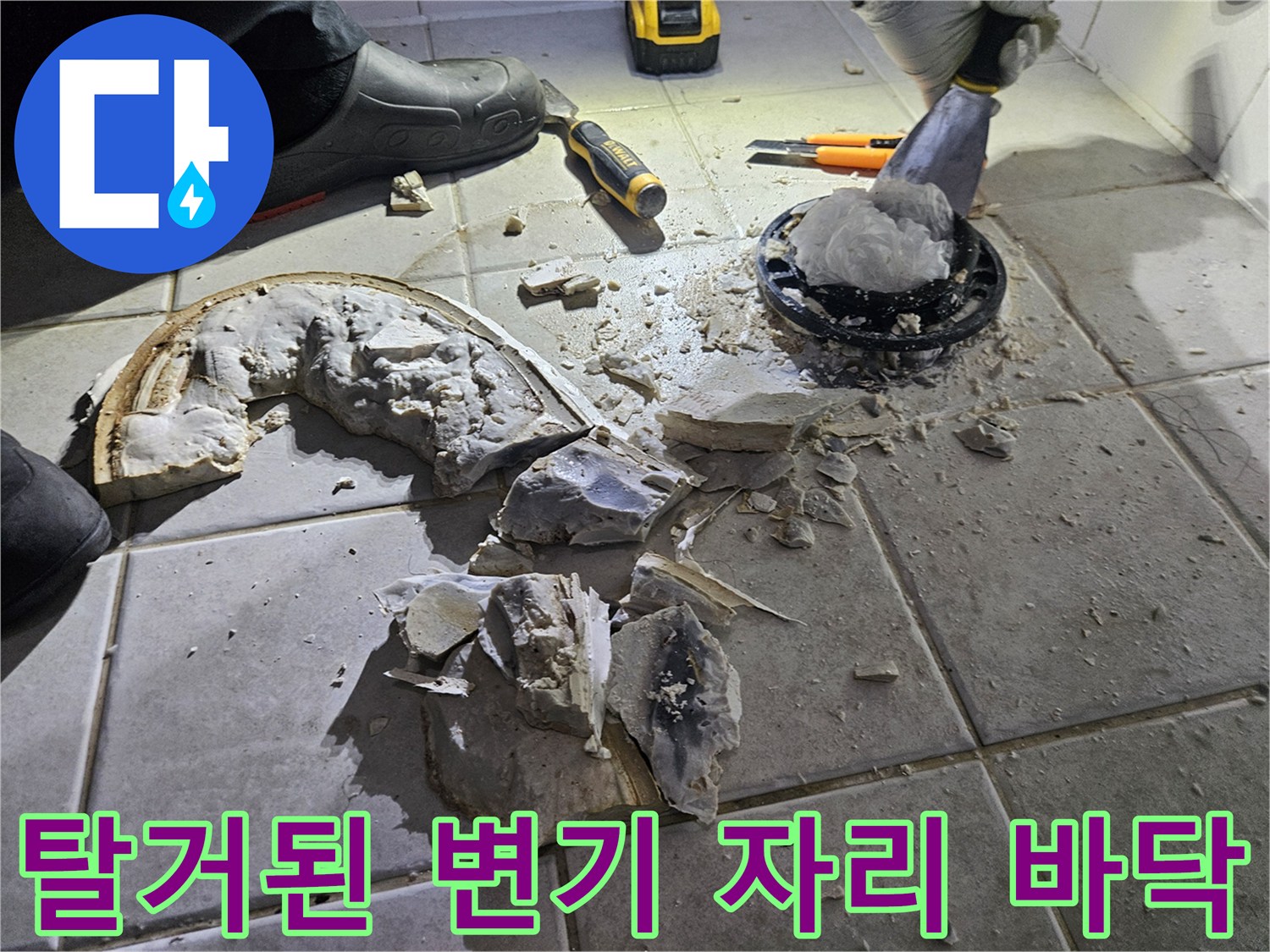 변기 제거 후 드러난 배관 주변의 깨진 타일과 시멘트 가루