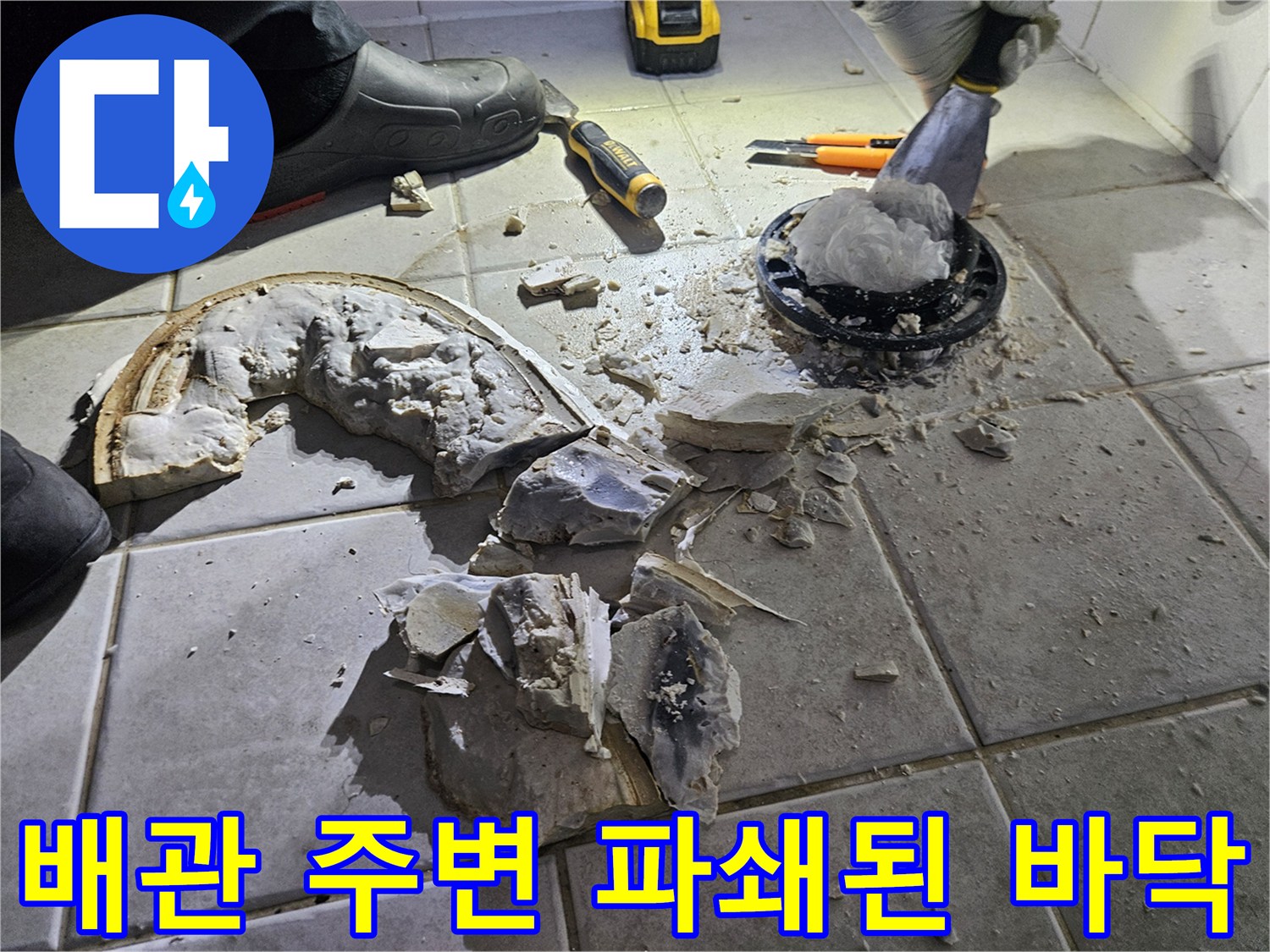 변기 제거 후 드러난 배관과 부서진 타일 조각들