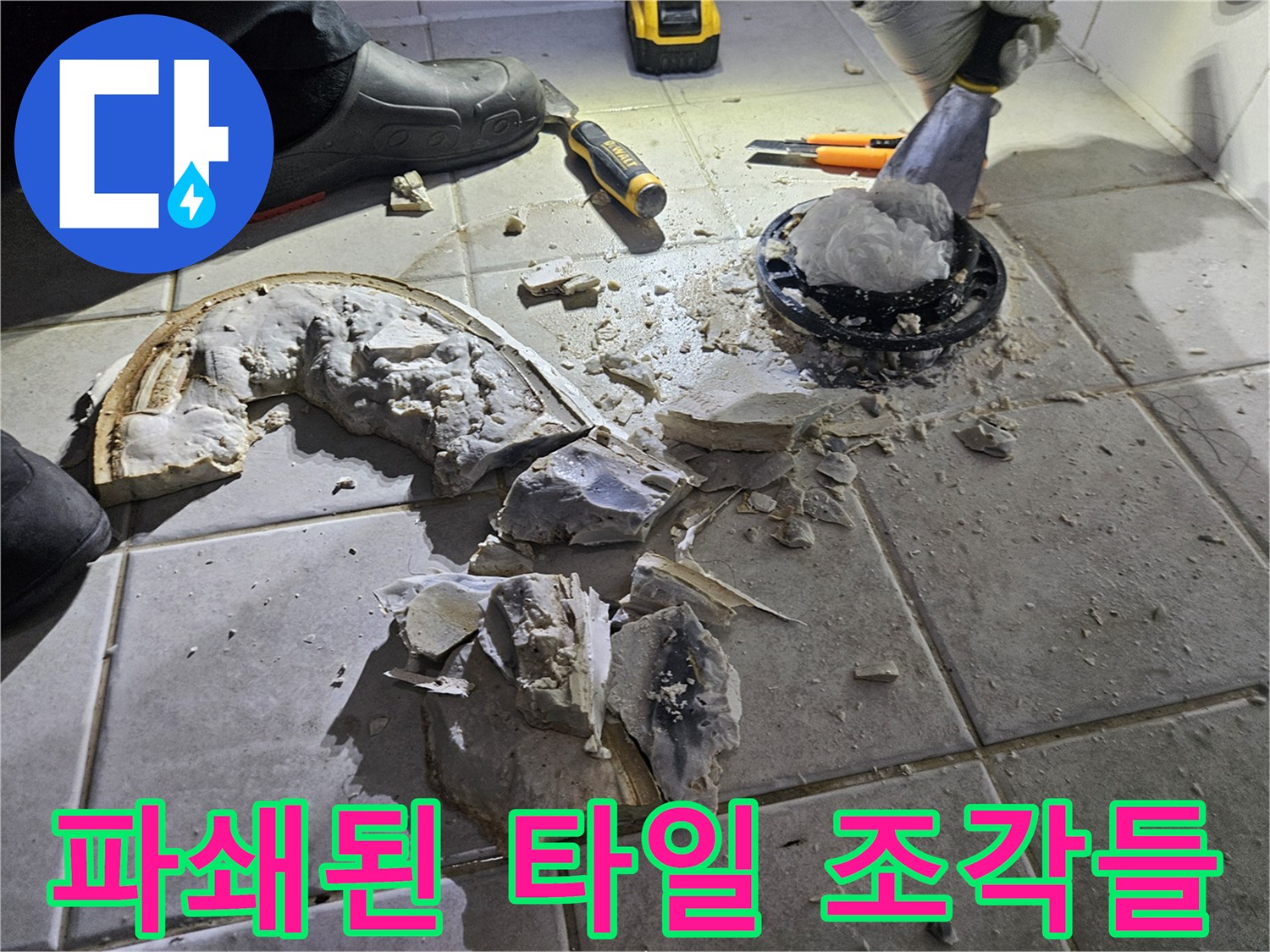 변기 탈거 후 드러난 배관 주변의 파손된 타일과 시멘트 파편입니다.