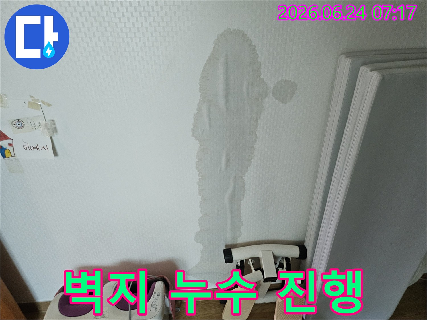 벽면을 따라 길게 물이 스며들어-벽지가 심하게 젖고 처진 누수 현장의 클로즈업 이미지