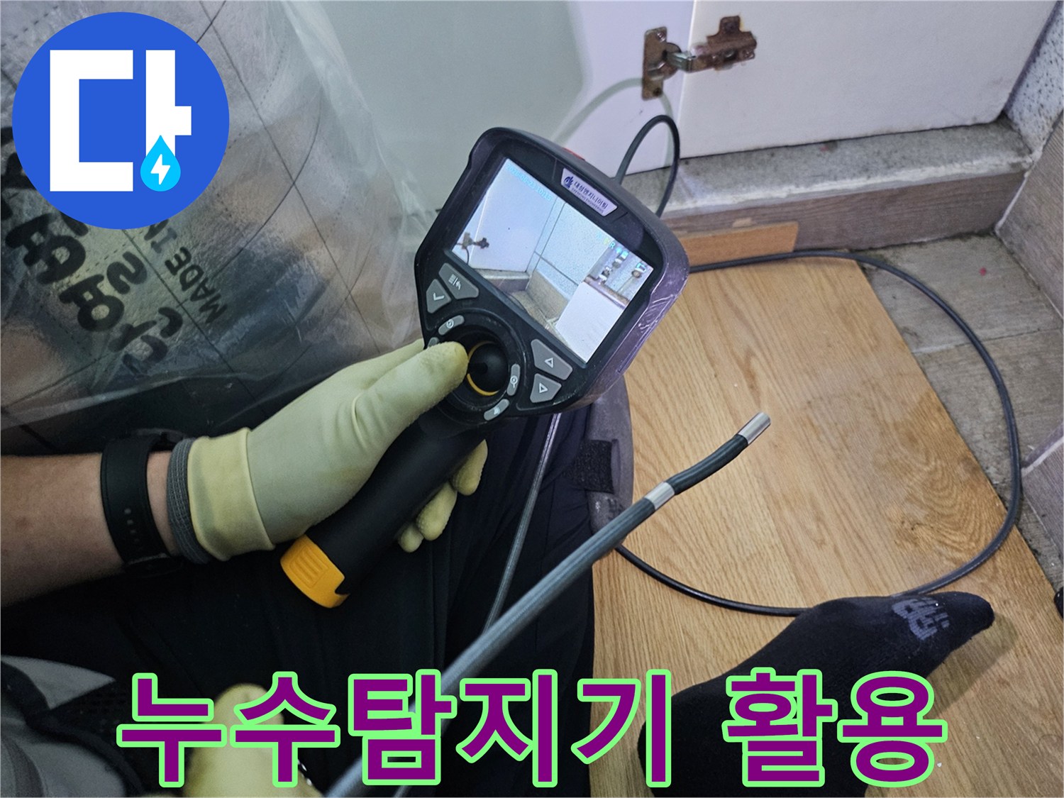 이 이미지는-숙련된 기술자가-누수 문제를 해결하고자-내시경 탐지기로-숨겨진 배관의 상태를 확인하는 과정입니다.