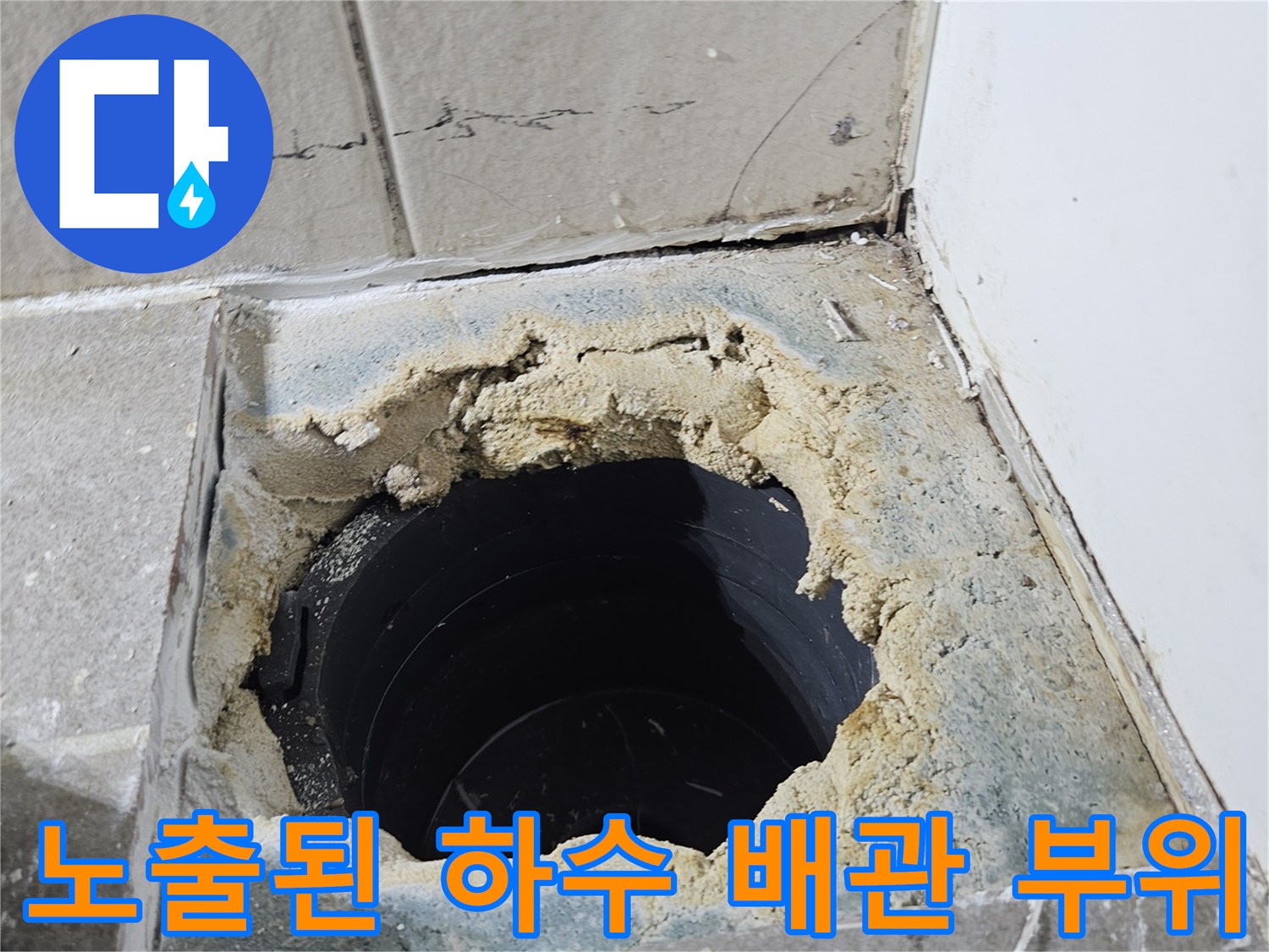 타일 제거 후 노출된 하수관과 주변의 거친 마감면입니다.