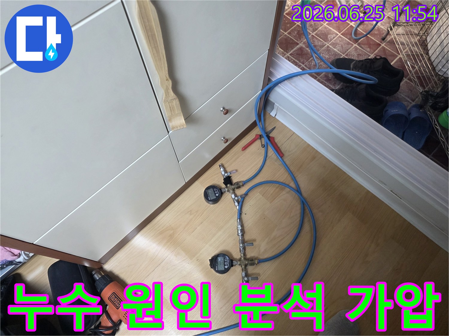 누수 엔지니어가 배관의 압력 변화를 감지하여 누수 여부를 확인하기 위해 디지털 게이지가 연결된 가압 테스트 장치를 설치하고 있습니다