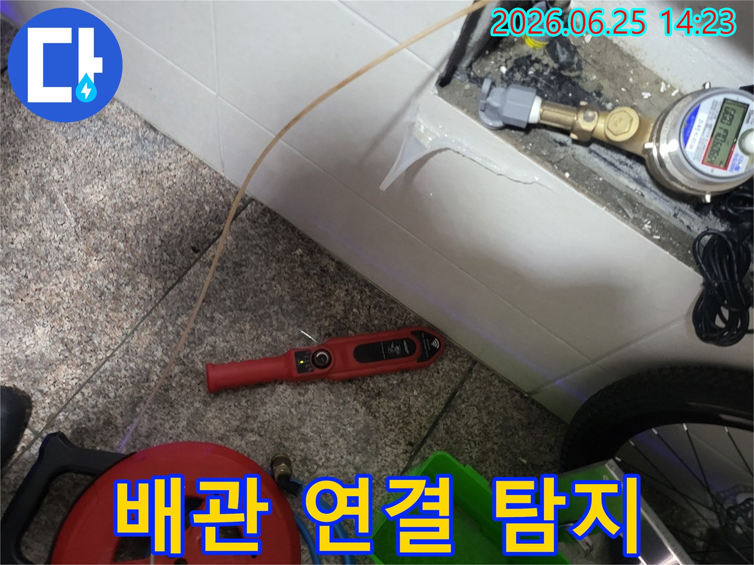 누수 탐지를 위해-수도 배관에 연결된-특수 호스와 장비들이-보이는 현장입니다.