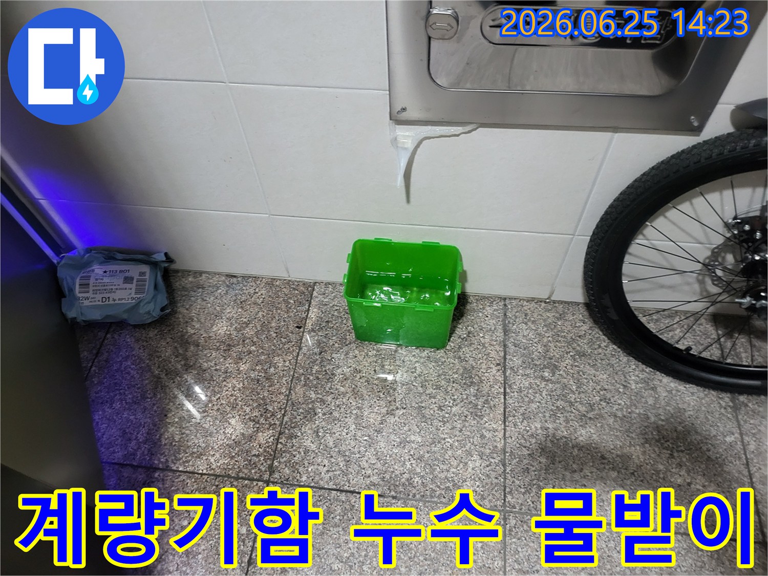 수도계량기함-아래에서-물이-새어-나와-초록색-물받이에-고이는-상황을-보여주는-누수-현장-사진