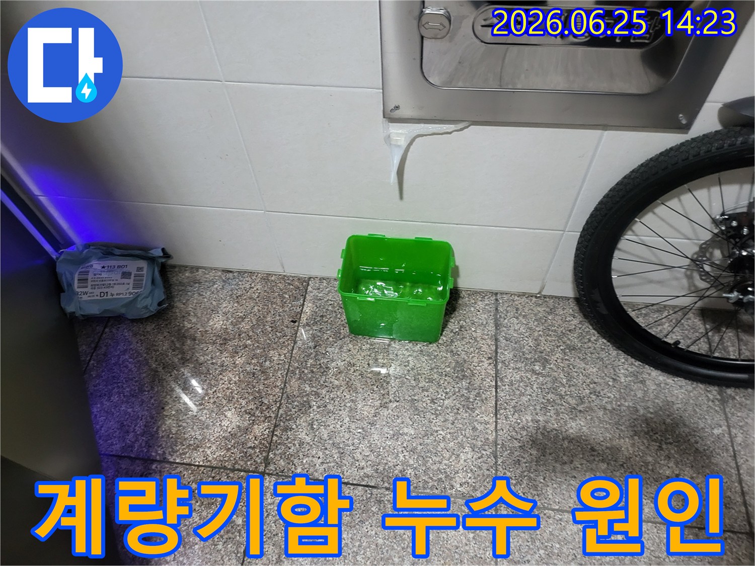 수도계량기함-아래에서-물이-새어-나와-초록색-물받이에-고이는-상황을-보여주는-누수-현장-사진