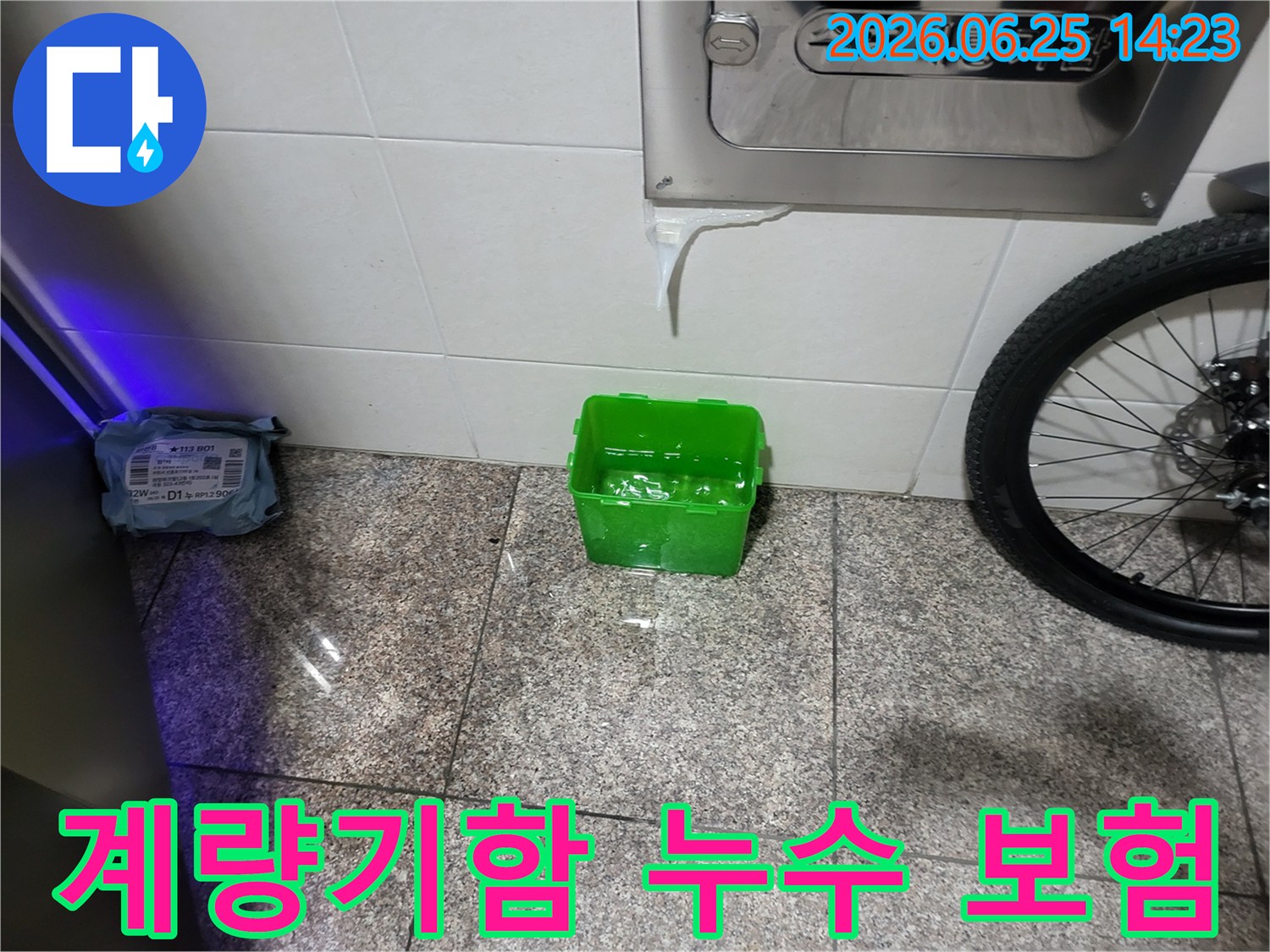 수도계량기함-아래에서-물이-새어-나와-초록색-물받이에-고이는-상황을-보여주는-누수-현장-사진