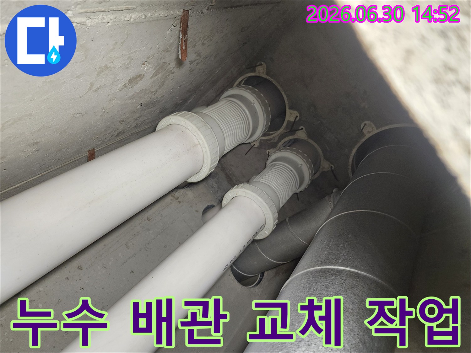 누수 공사 현장에서 촬영된 것으로-PVC 파이프와 금속 덕트가 함께 설치된-배관 구조를 상세히 보여줍니다.