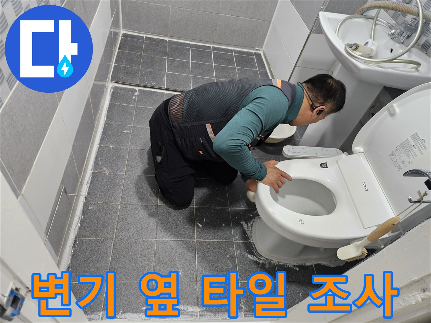 작업자가 변기 아래쪽 타일 마감 상태를 꼼꼼하게 확인하고 있습니다.