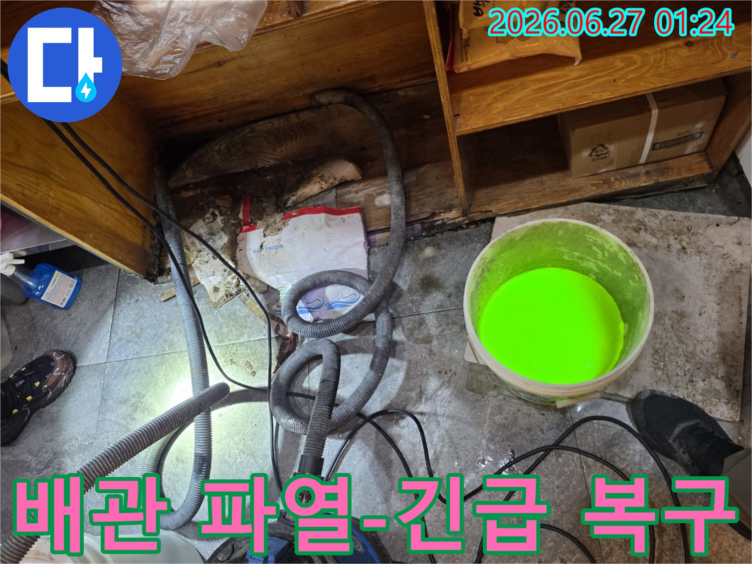 이 이미지는-서초구의 한 건물에서-배관 파열로 인한 누수 발생 시-긴급 복구 작업을 위해-현장을 준비하는 모습을 보여줍니다.