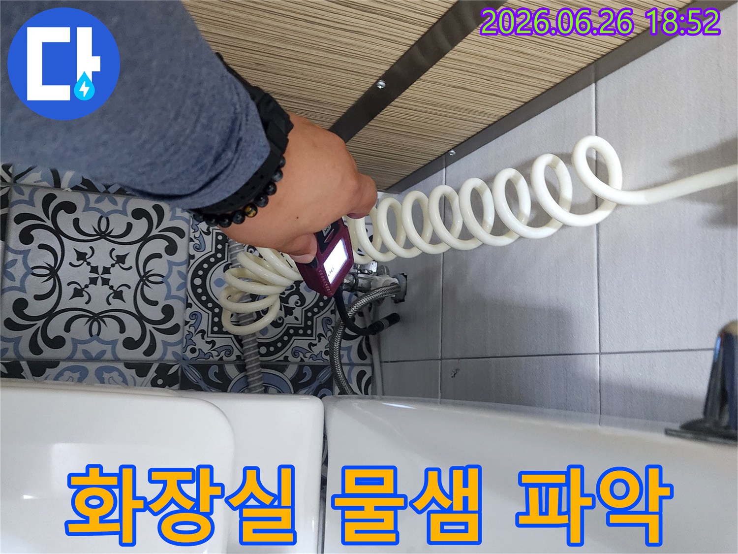 누수 엔지니어가 화장실 변기 옆에서 전문 탐지 장비로 물샘 지점을 확인하고 있습니다.