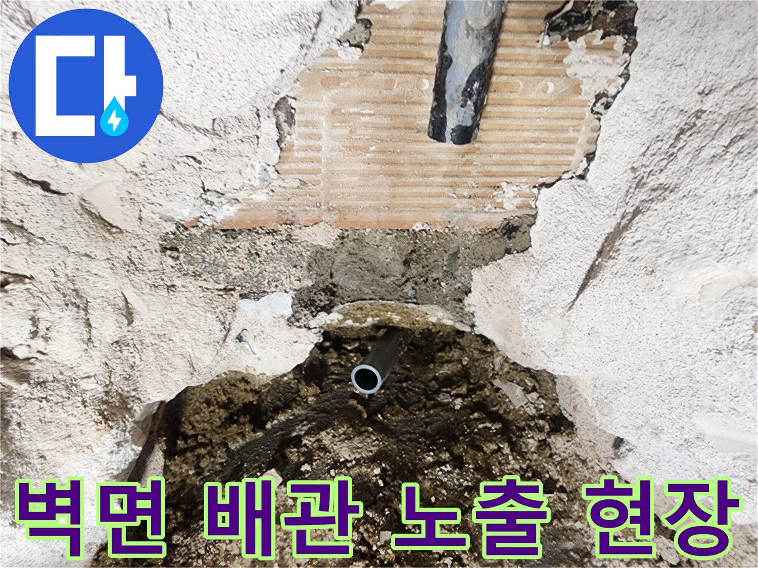 화장실 벽면 타일 제거 후-노출된 배관과 젖은 콘크리트 상태