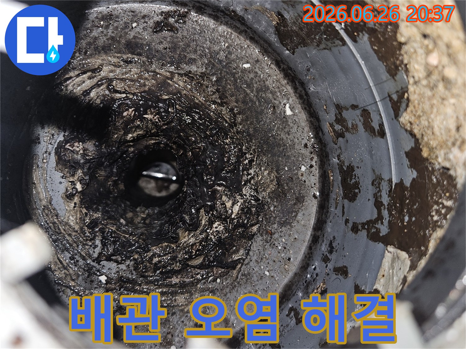 이 이미지는 배관 내부의 심각한 오염으로 인해-배수 불량이 발생한 상황을 보여주며-해결 전의 모습을 담고 있습니다.