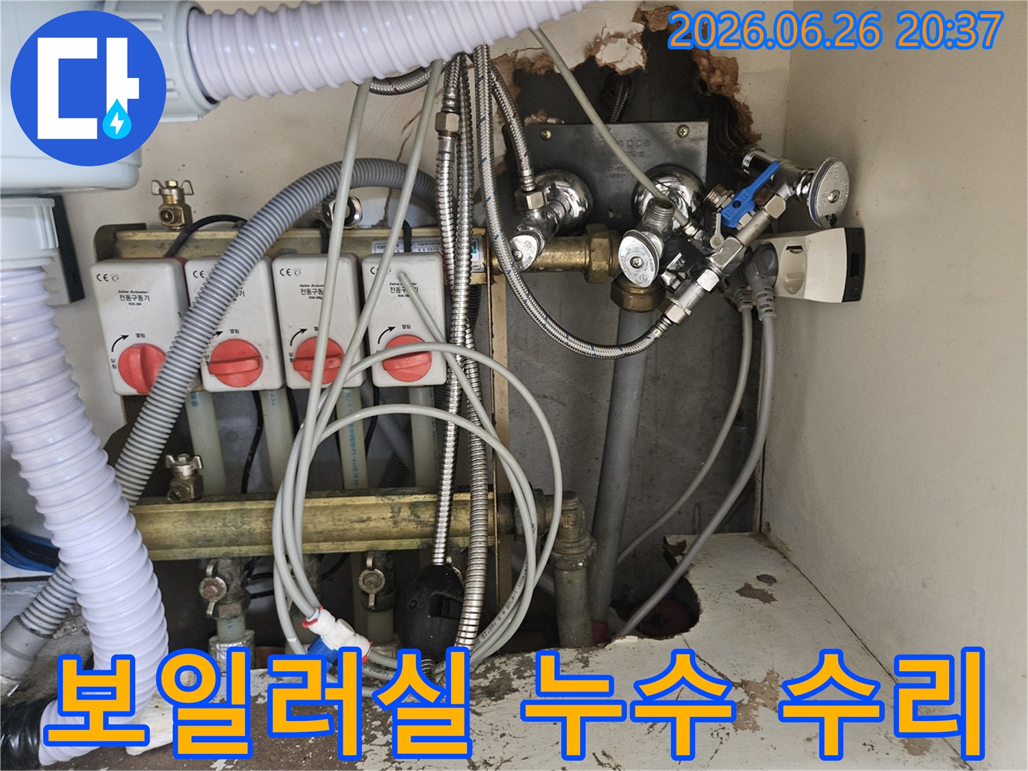 이 이미지는-보일러실의-복잡한 배관과-전기 콘센트-그리고-벽면의 손상된-부분을-보여주는-누수 현장입니다