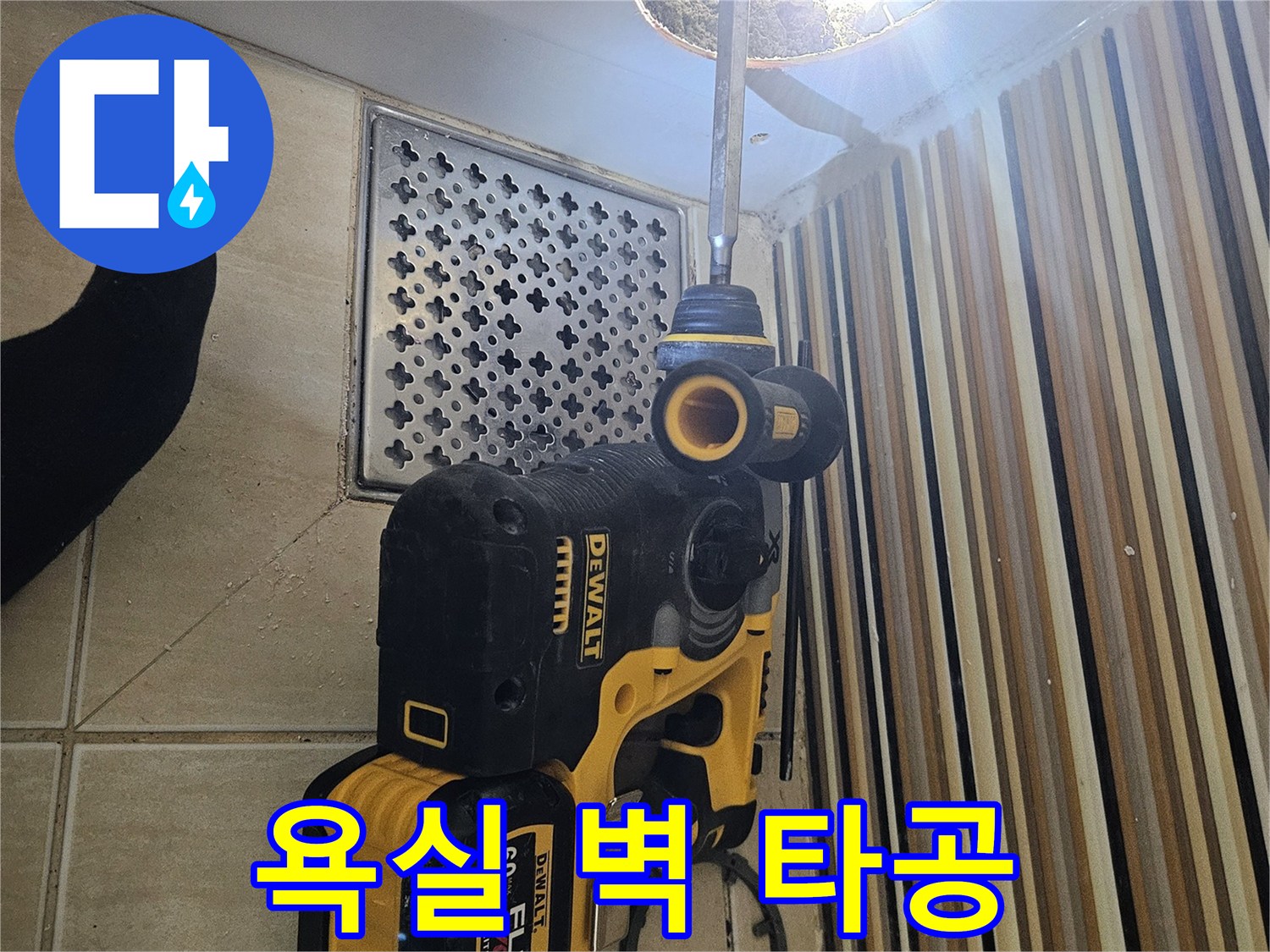 드릴을 사용하여 화장실 내부 점검구를 만들기 위한 작업