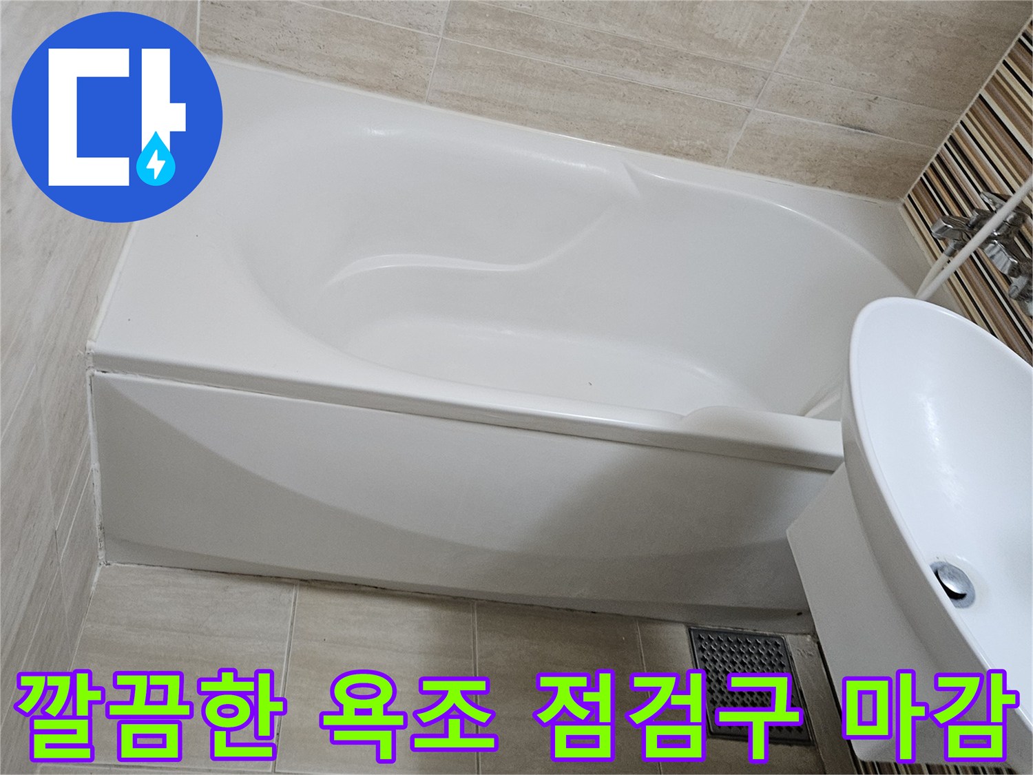 욕조 옆면의 하얀색 점검구 덮개와 주변 타일 마감 상태입니다.