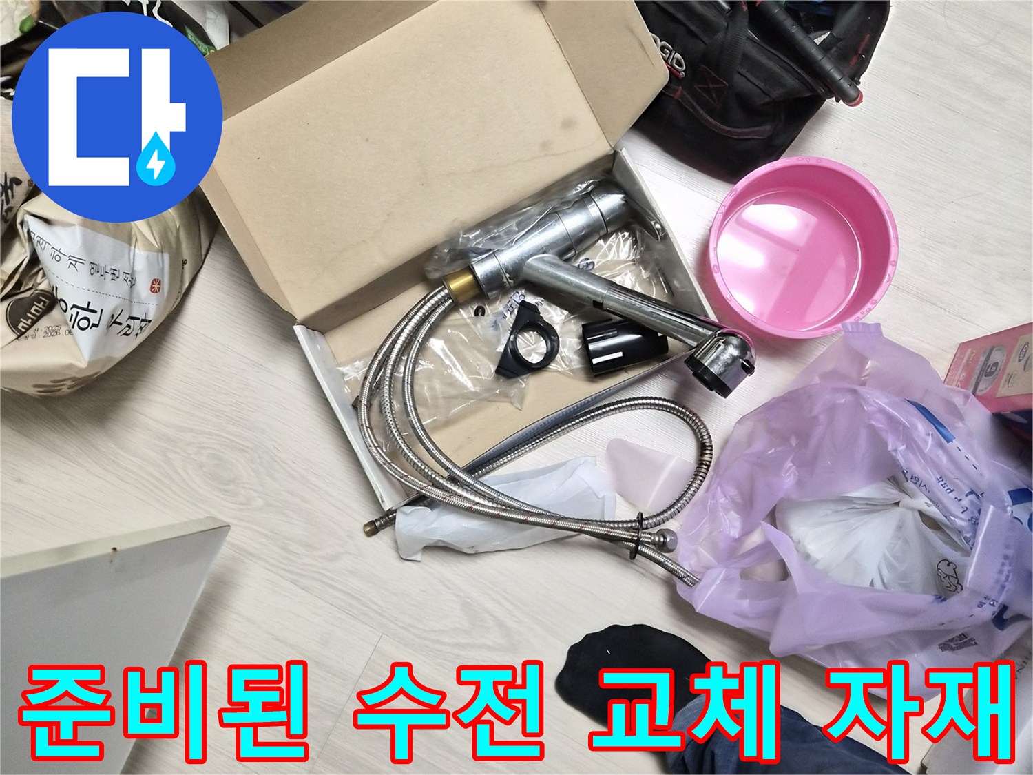 교체용 싱크대 수전과 작업 도구들이 놓인 바닥 모습