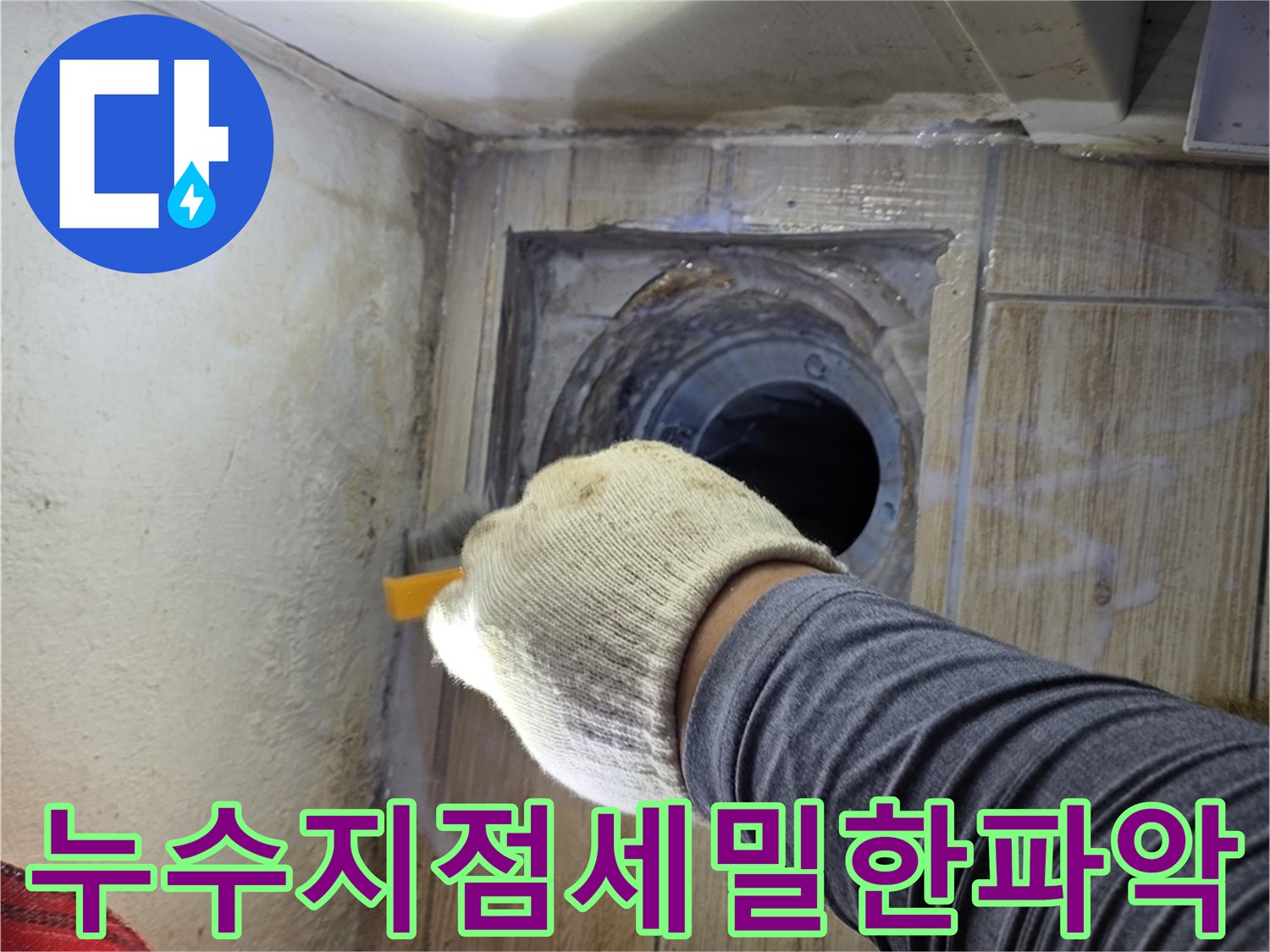 강력 조명으로 세탁실 배수구 주변의 미세 균열을 확인하며 누수 경로를 파악하는 장면