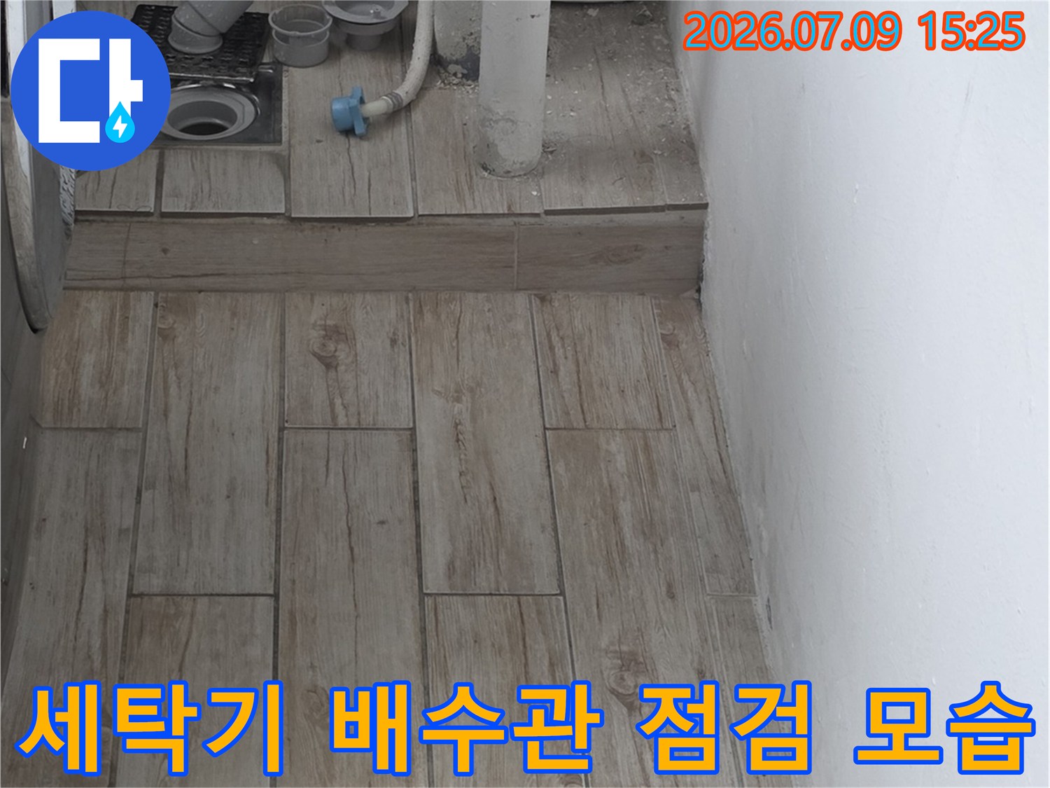 세탁기 배수 호스 연결 부위와 벽면 마감재를 촬영한 사진