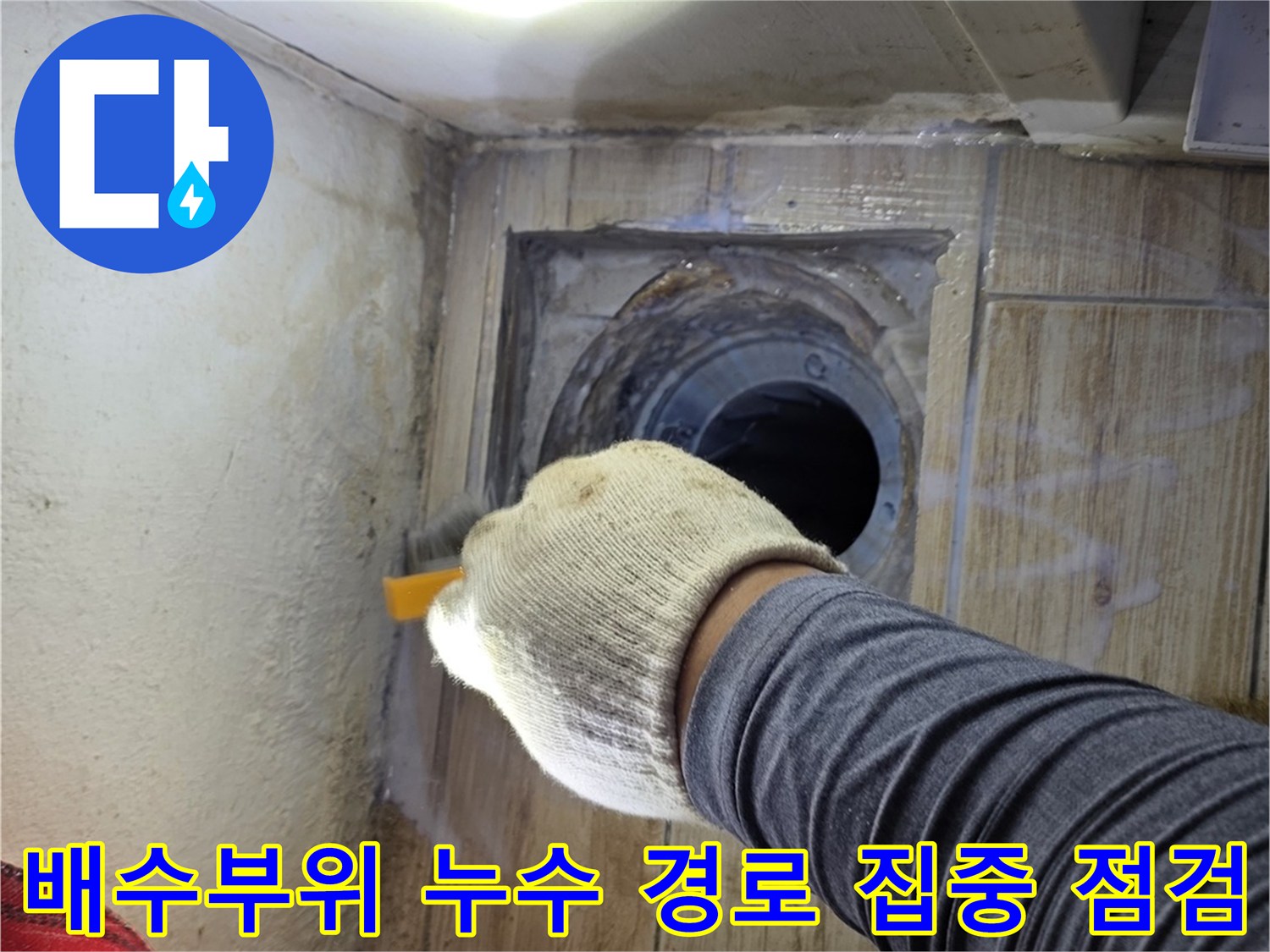 조명을 활용해 세탁실 배수구 주변의 방수 상태를 정밀하게 진찰하는 현장 사진