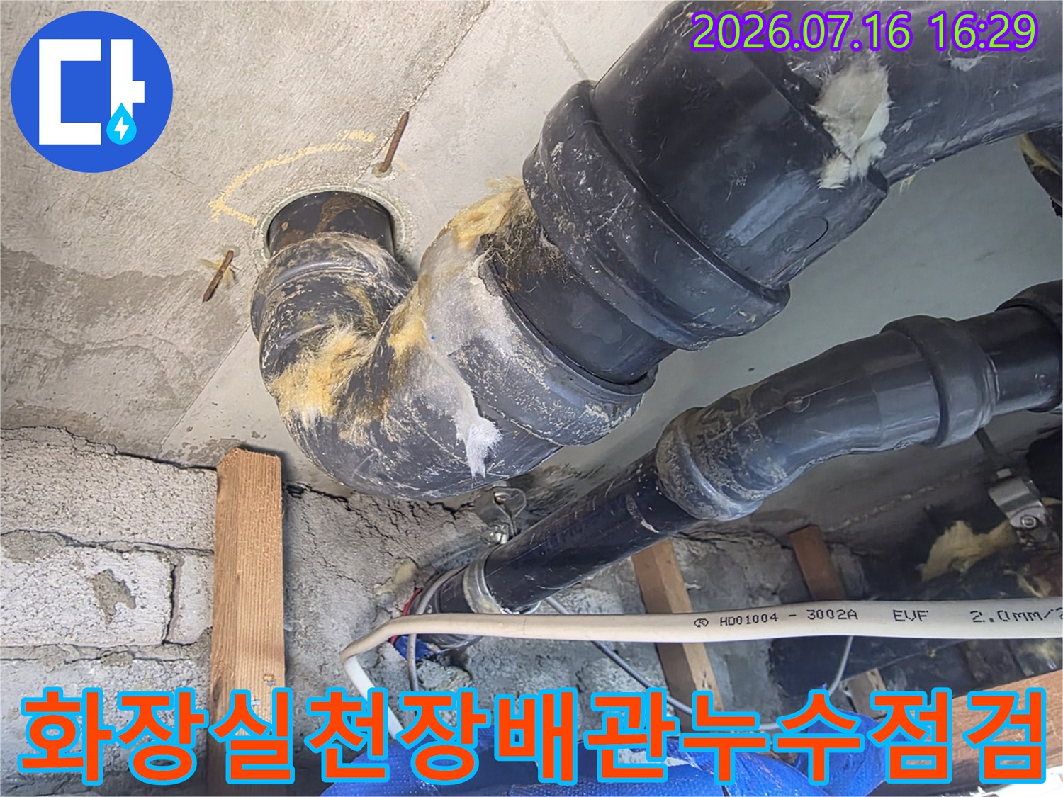 화장실 천장 내부의 노출된 배관과 누수 흔적이 있는 연결 부위 점검 모습
