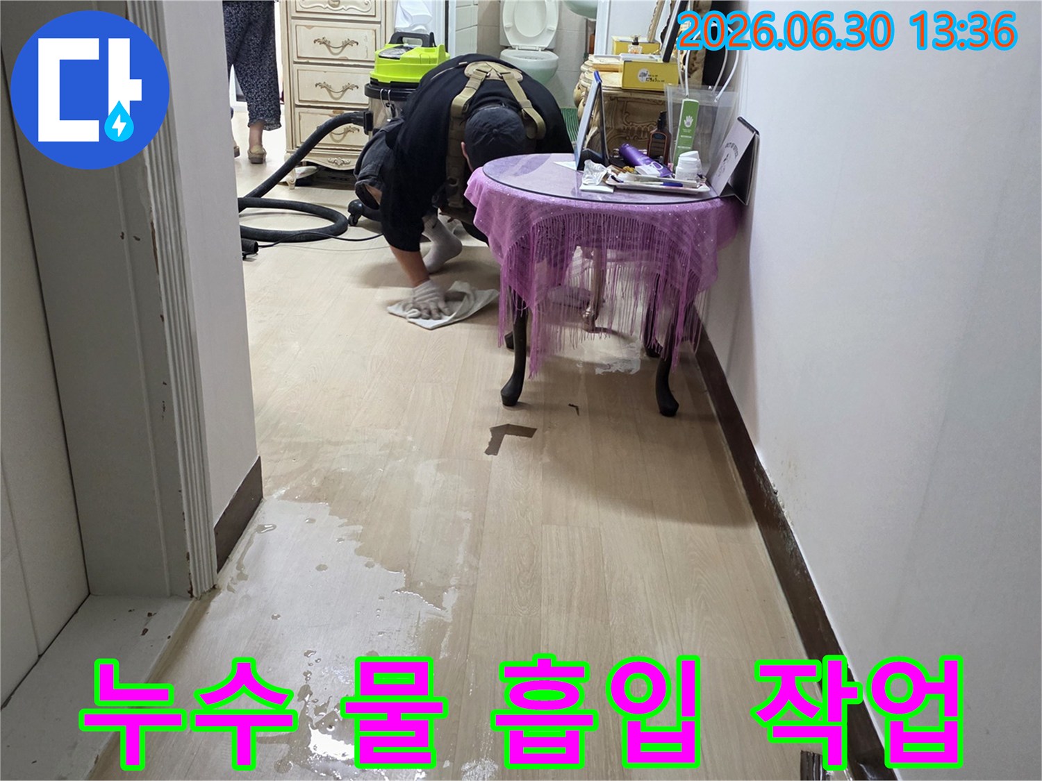 누수-현장에서-전문가가-산업용-습식-청소기로-바닥의-물을-흡입하여-제거하는-모습