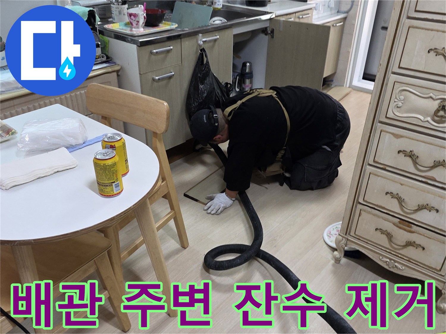 싱크대 배수 호스 주변의 물기를 제거하기 위해 집진기를 사용하는 엔지니어