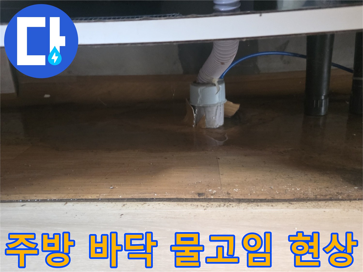 싱크대 하단 배수구 주변에 고여 있는 물과 젖은 마감재