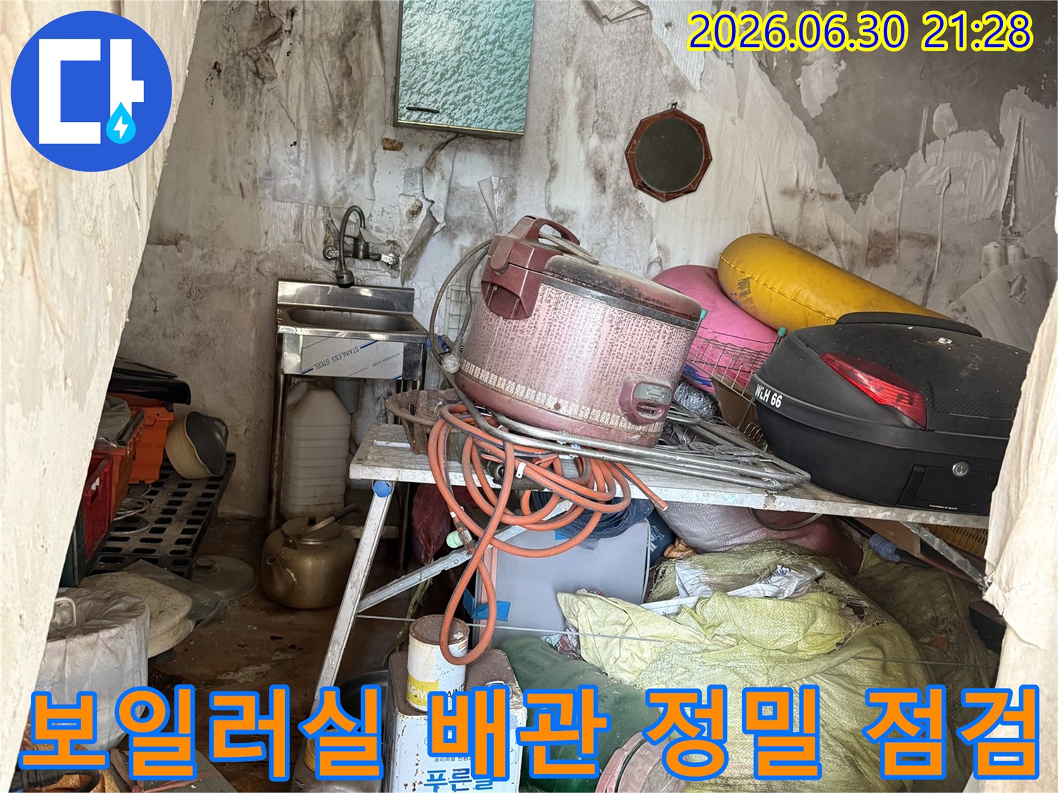 복잡하게 얽힌 보일러실 내부 배관과 주변 집기들을 살피며 누수 위치를 파악하는 모습