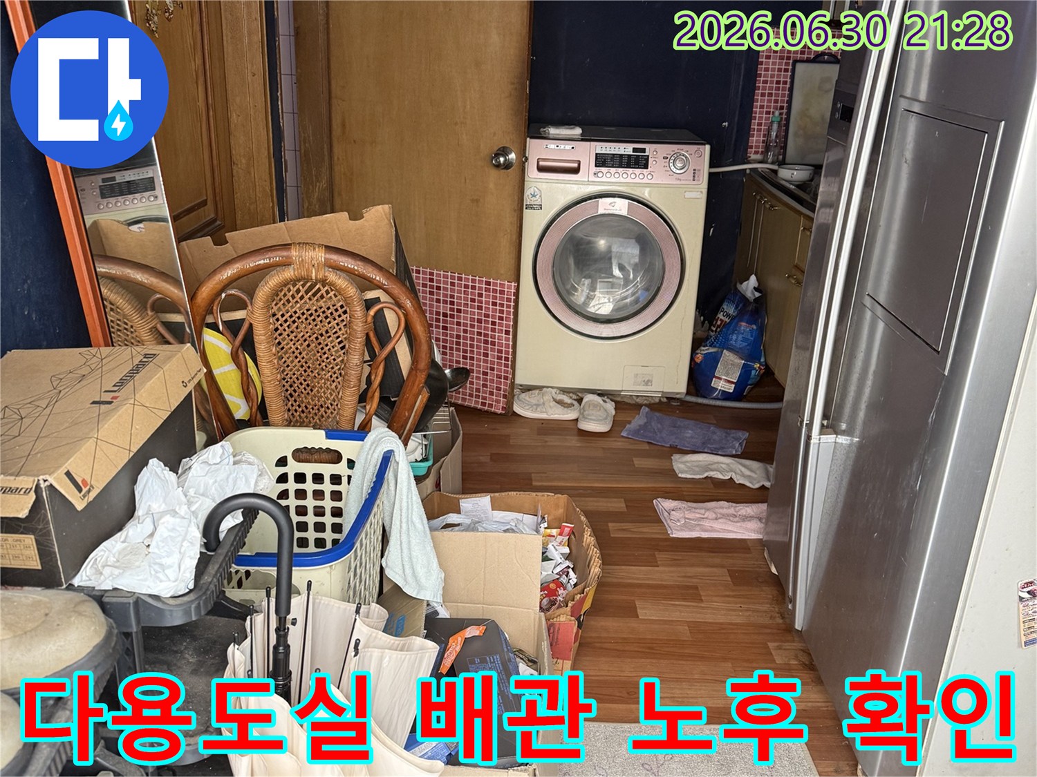 세탁기가 있는 공간의 배관 연결 부위와 주변 환경을 조사하는 현장 사진