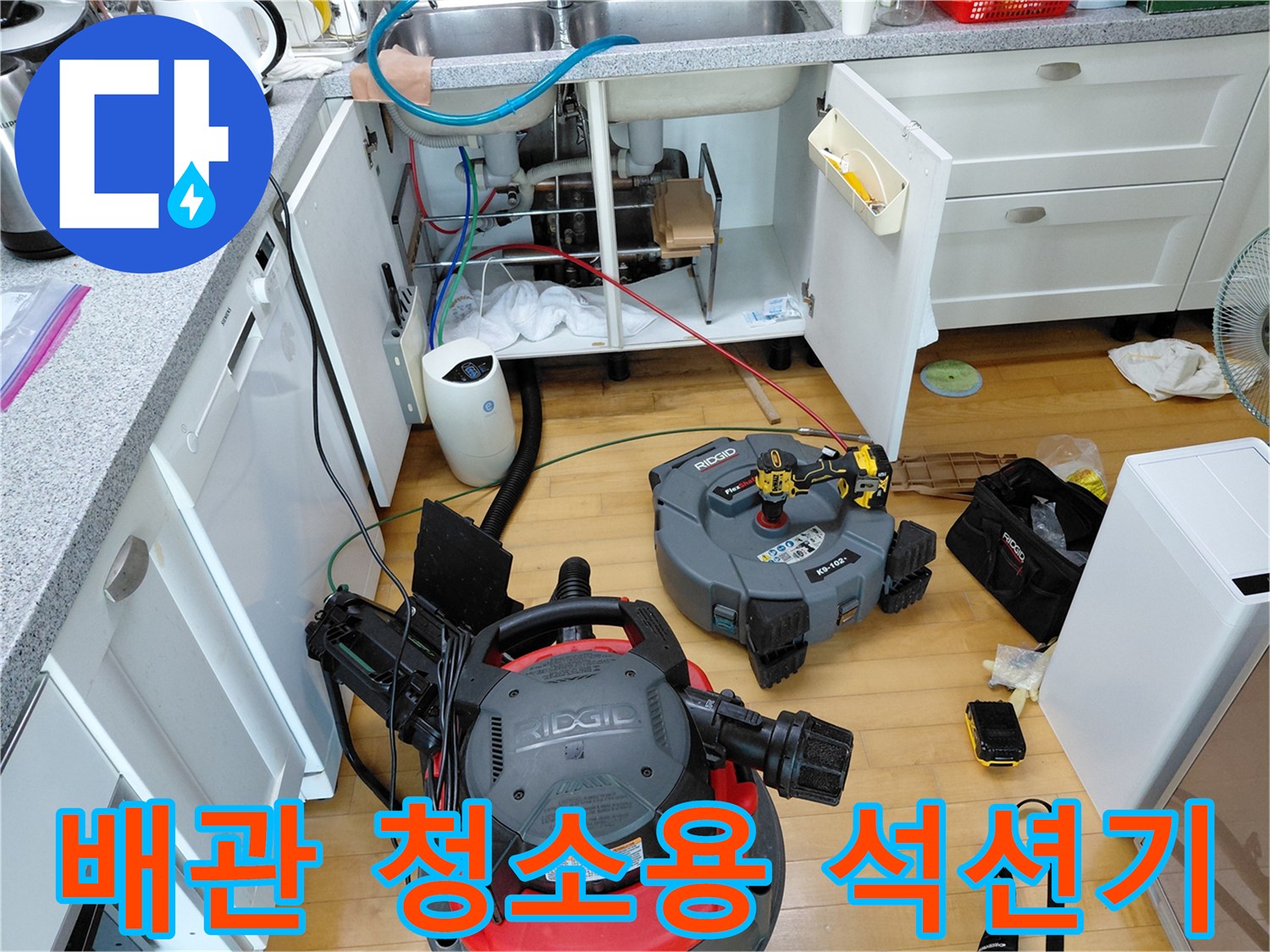주방 싱크대 밑-배관 세척을 위해 설치된 대형 석션 장비와 공구