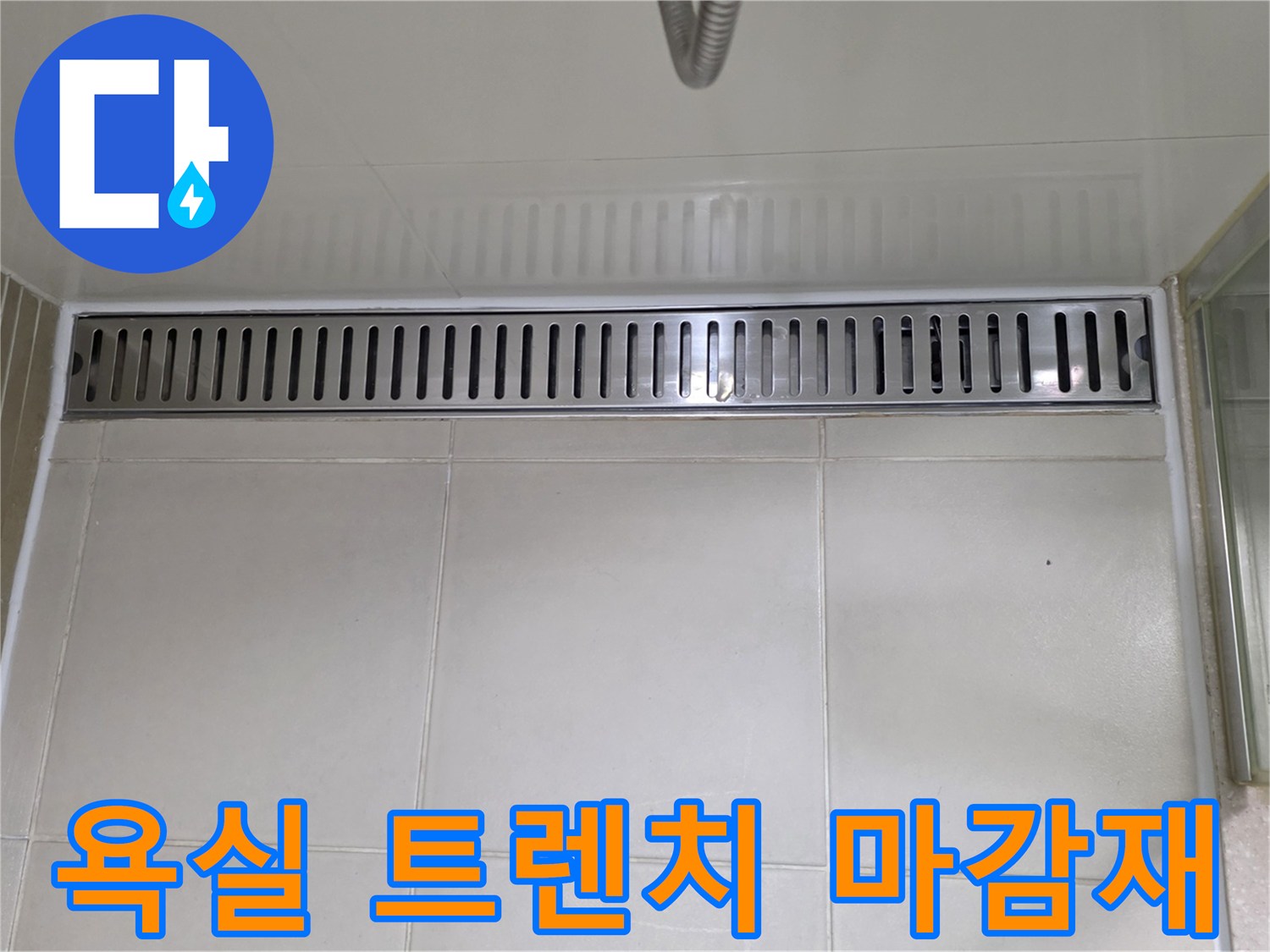 밝은색 타일과 스테인리스 배수구가 만나는 지점