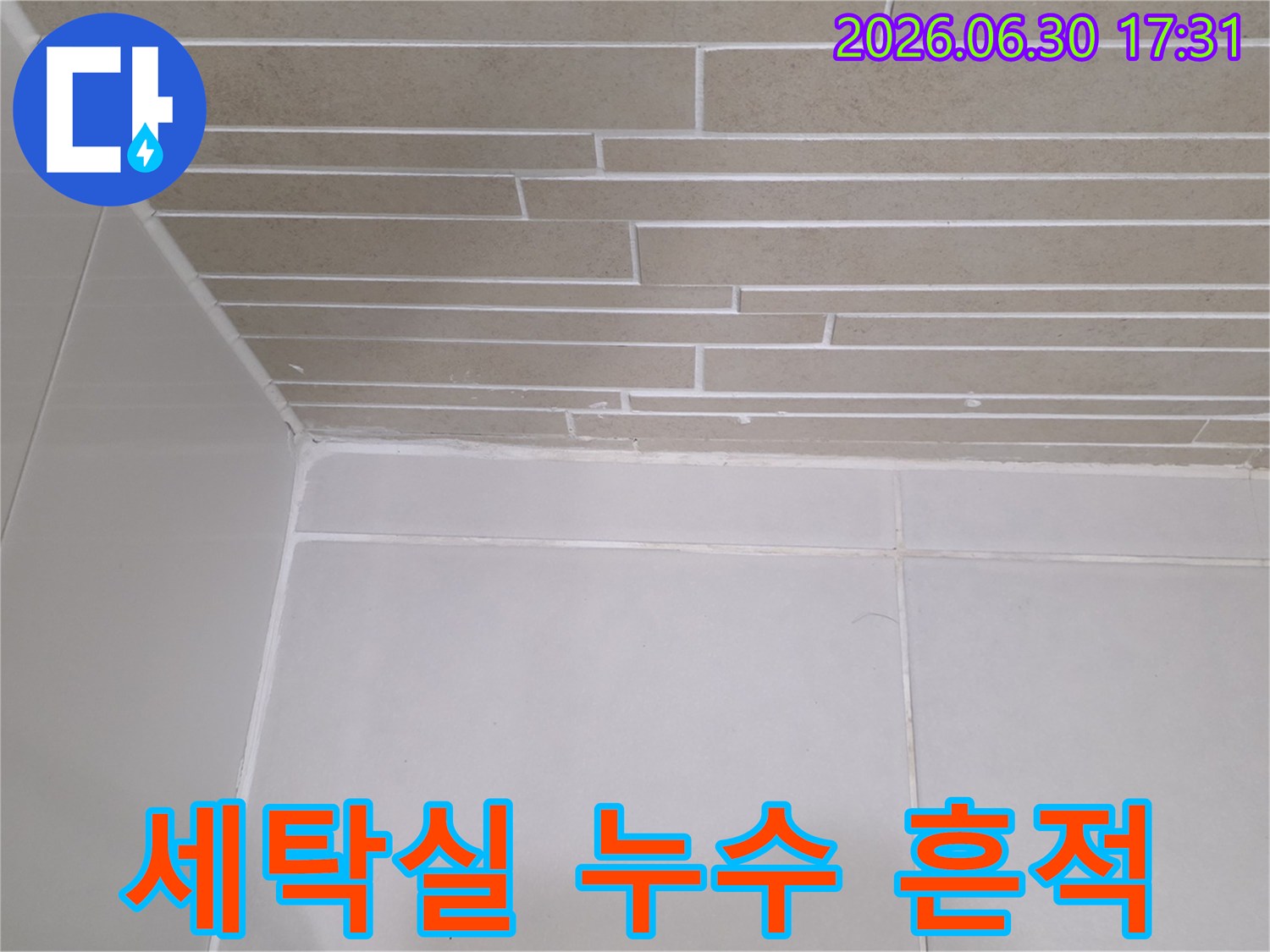 이 이미지는-용산더프라임 아파트의 세탁실에서-누수가 발생하여-벽면이 손상된 현장을-보여줍니다
