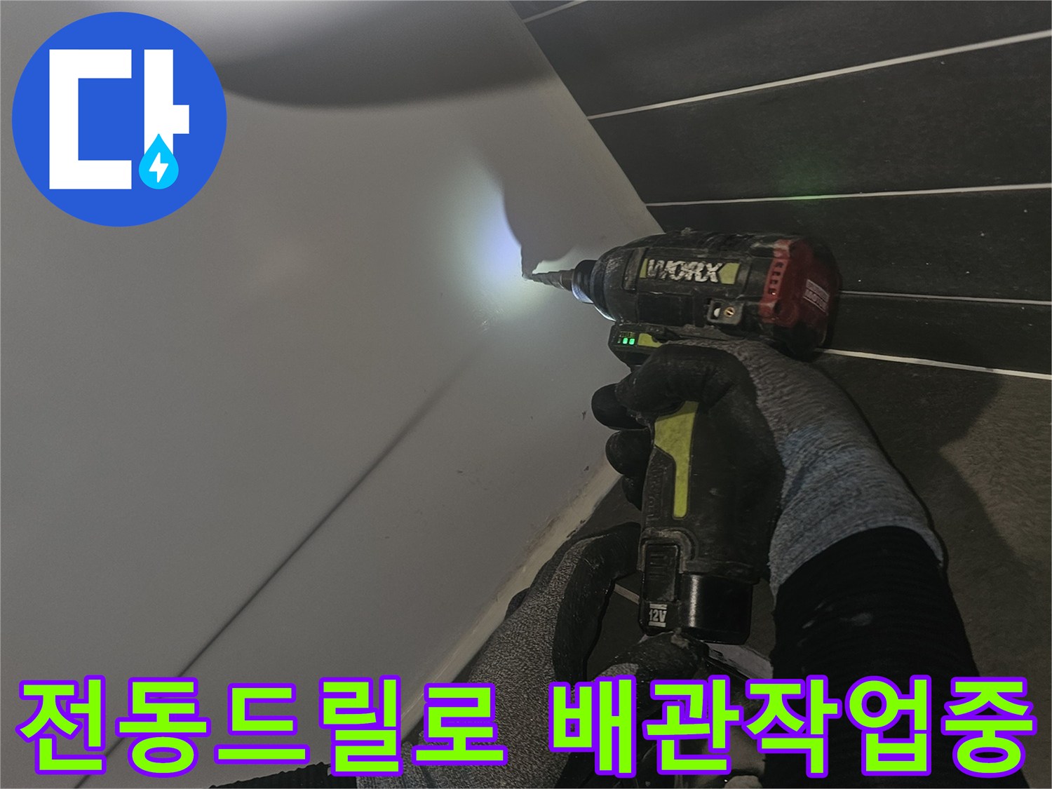 화장실 배관 보수를 위해 전동 드릴을 사용하는 모습입니다.