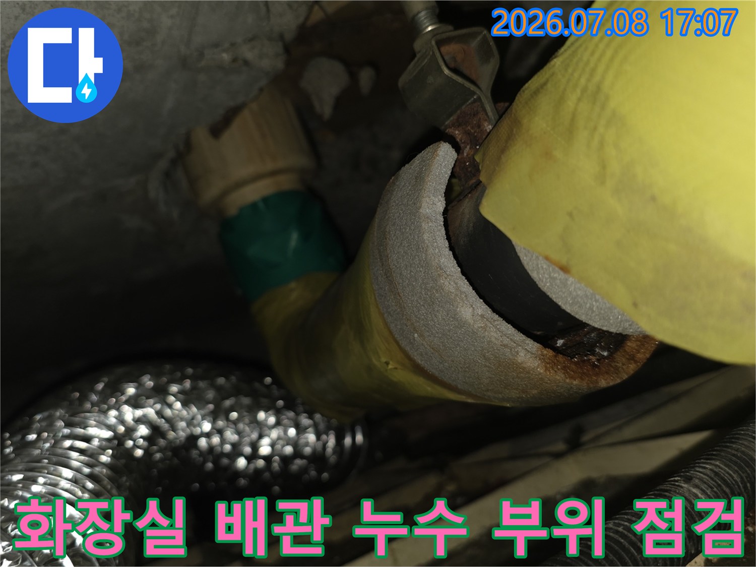 노출된 화장실 하수관과 배관 연결 부위를 정밀하게 점검하는 모습