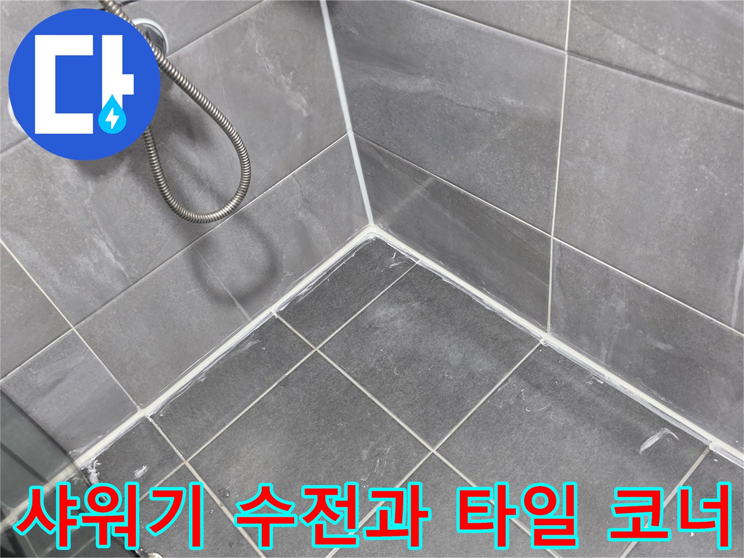 샤워기 수전 아래쪽의 회색 타일 벽면과 바닥이 만나는 지점의 클로상 촬영
