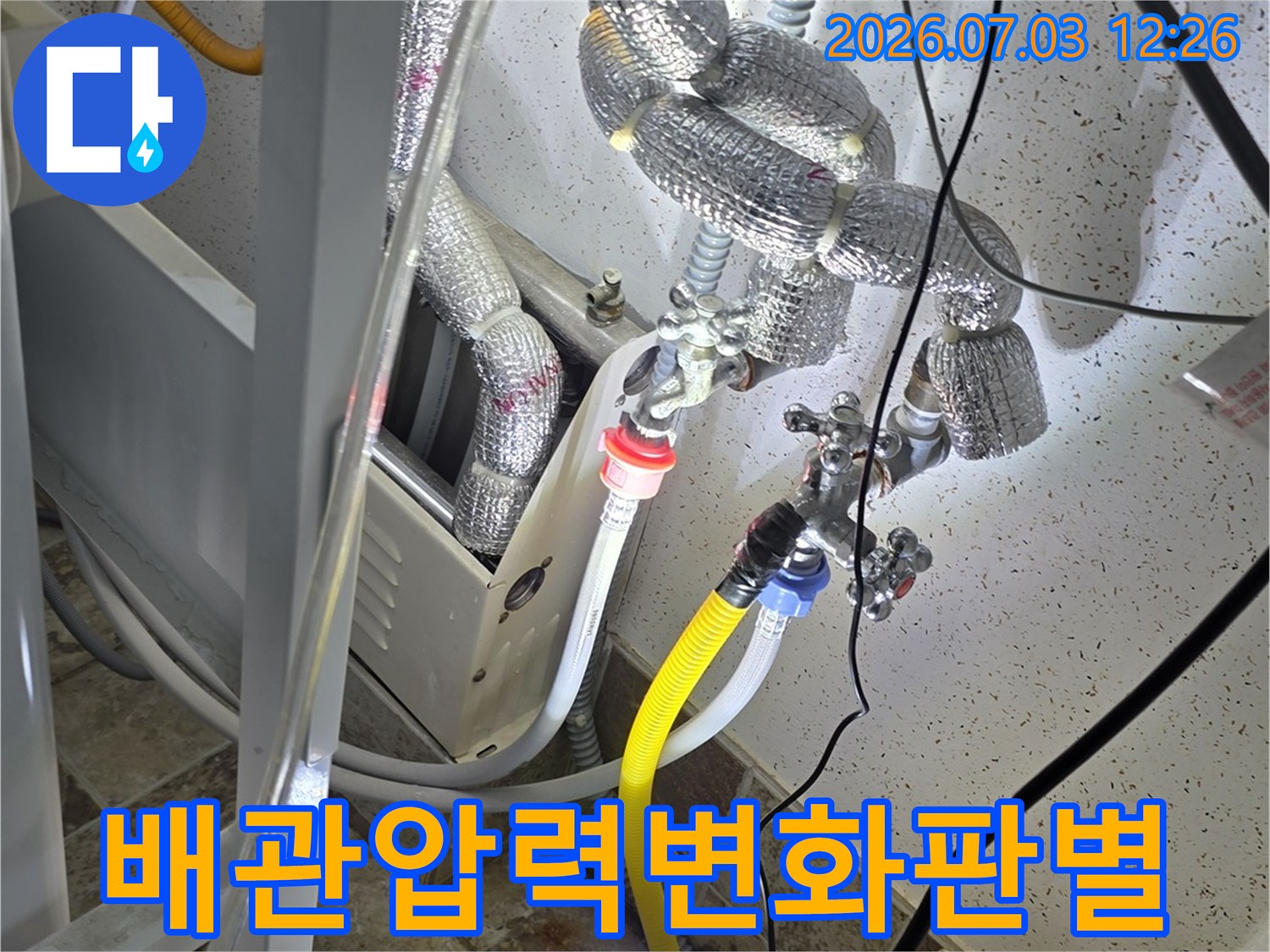 노출된 배관 라인에 공압 게이지를 연결하여 누수 여부를 판별하는 정교한 작업 모습