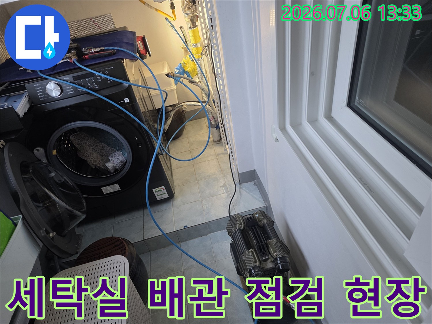 세탁기 옆에 위치한 노출 배관과 복잡한 배관 시스템 점검 장면