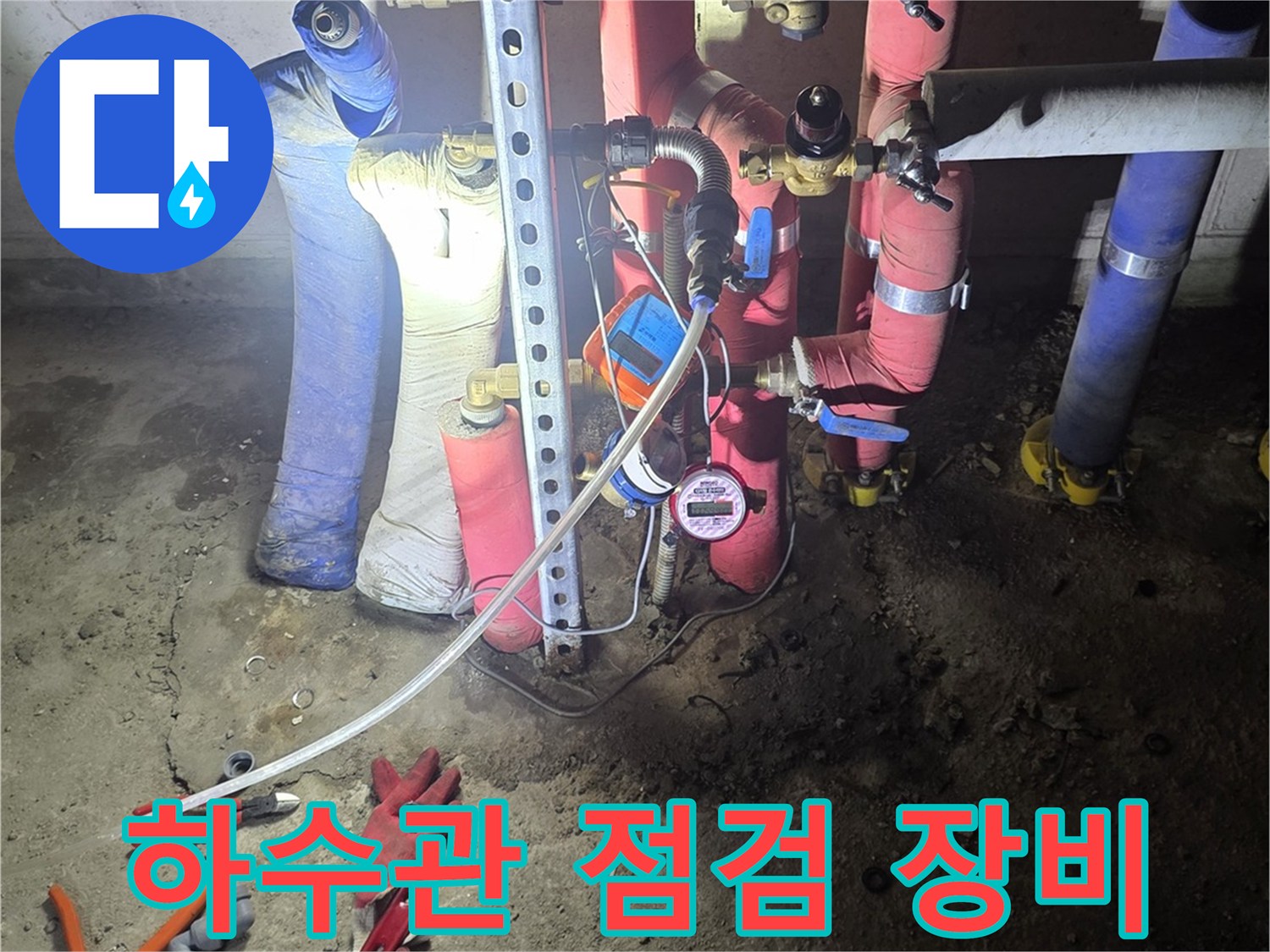 싱크대 아래 배관 부위와 압력 측정 장비가 놓여 있는 모습
