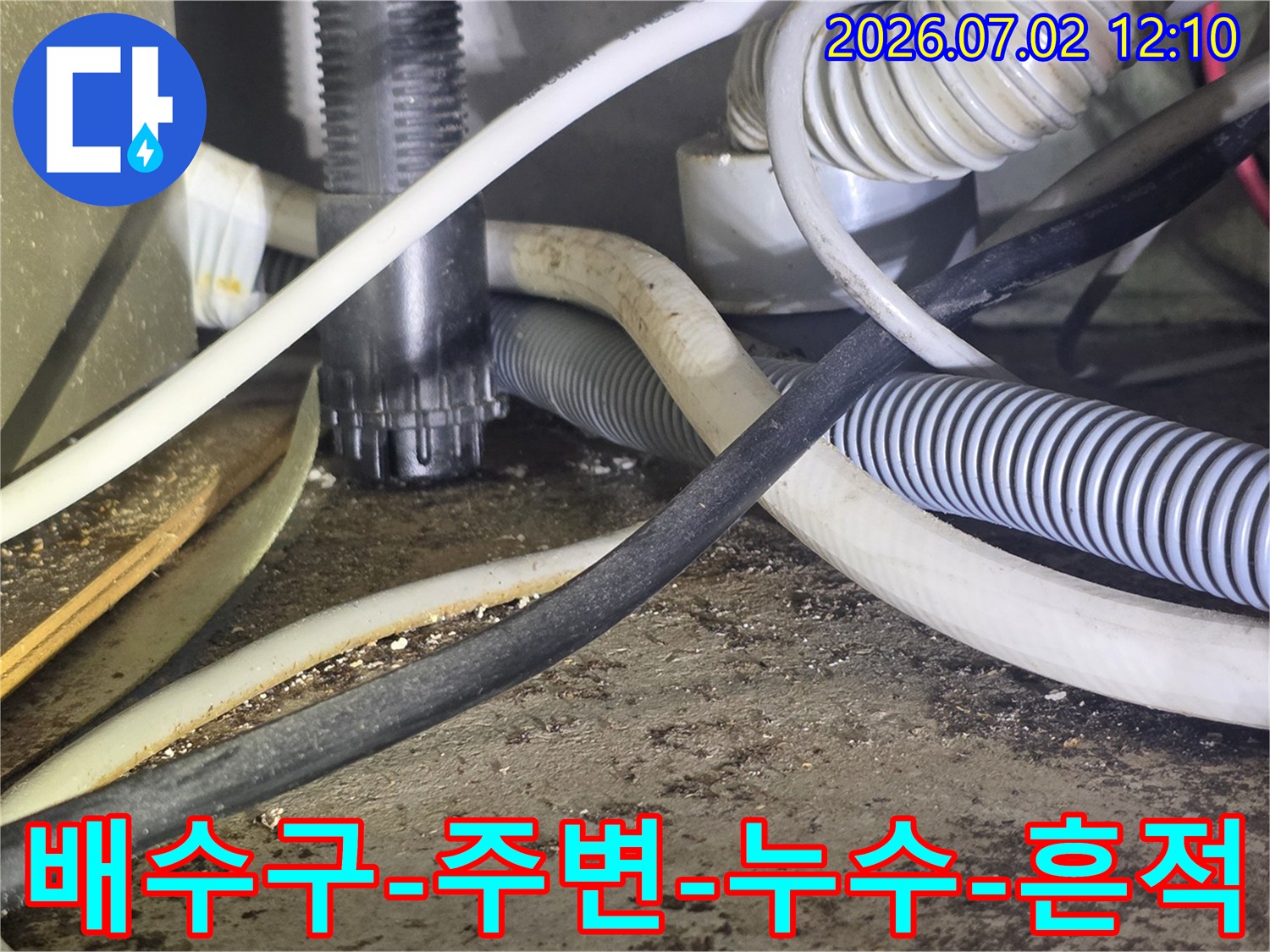 이 사진은-배수구 주변의-복잡한 배관과-누수 흔적을-보여주는-현장 이미지입니다.