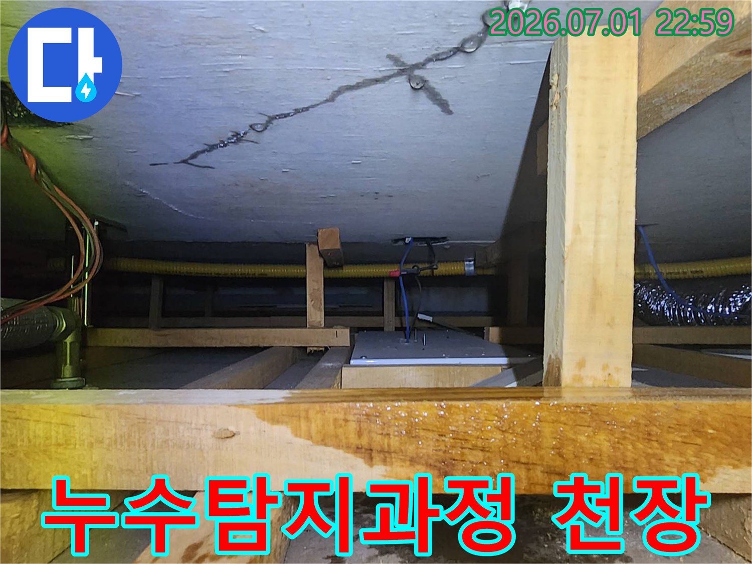 천장 균열과 젖은 목재 구조물-그리고 배관이 보이는-누수 탐지 현장 사진입니다.