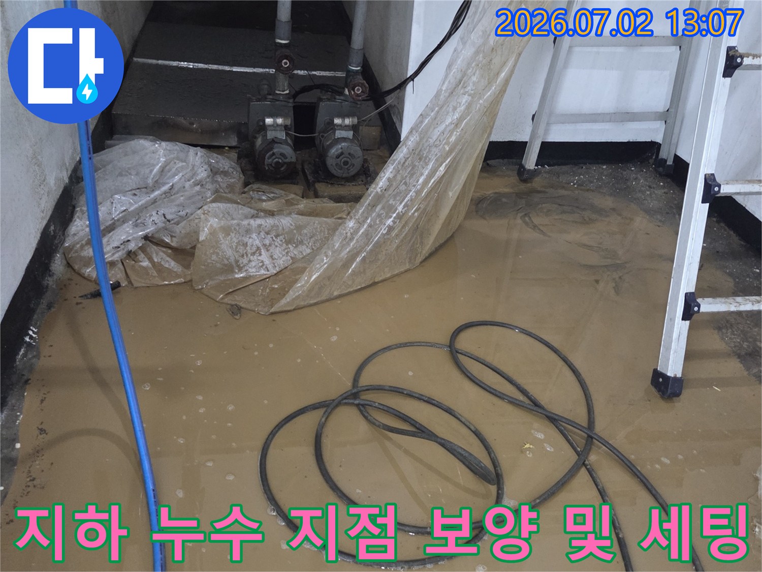 작업용 사다리와 파란색 호스가 놓여 있는 지하 배관 현장-누수 진단을 위한 준비 상태