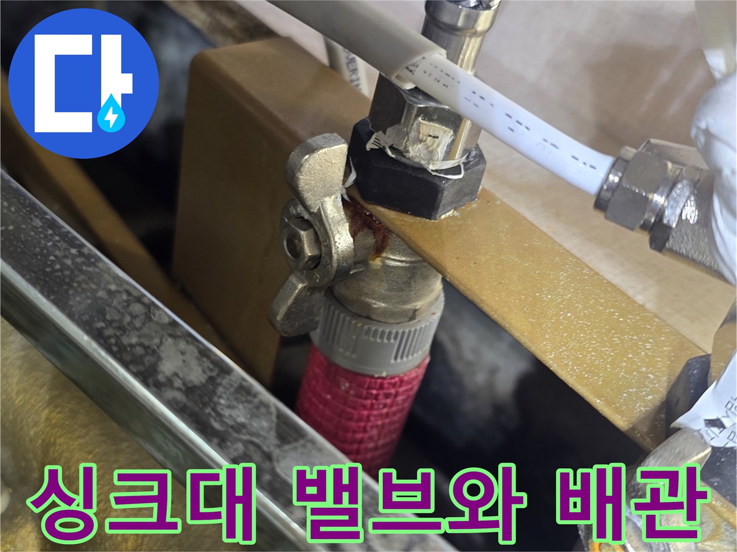 싱크대 하단에 설치된-수도 밸브와 연결 호스 근접 촬영